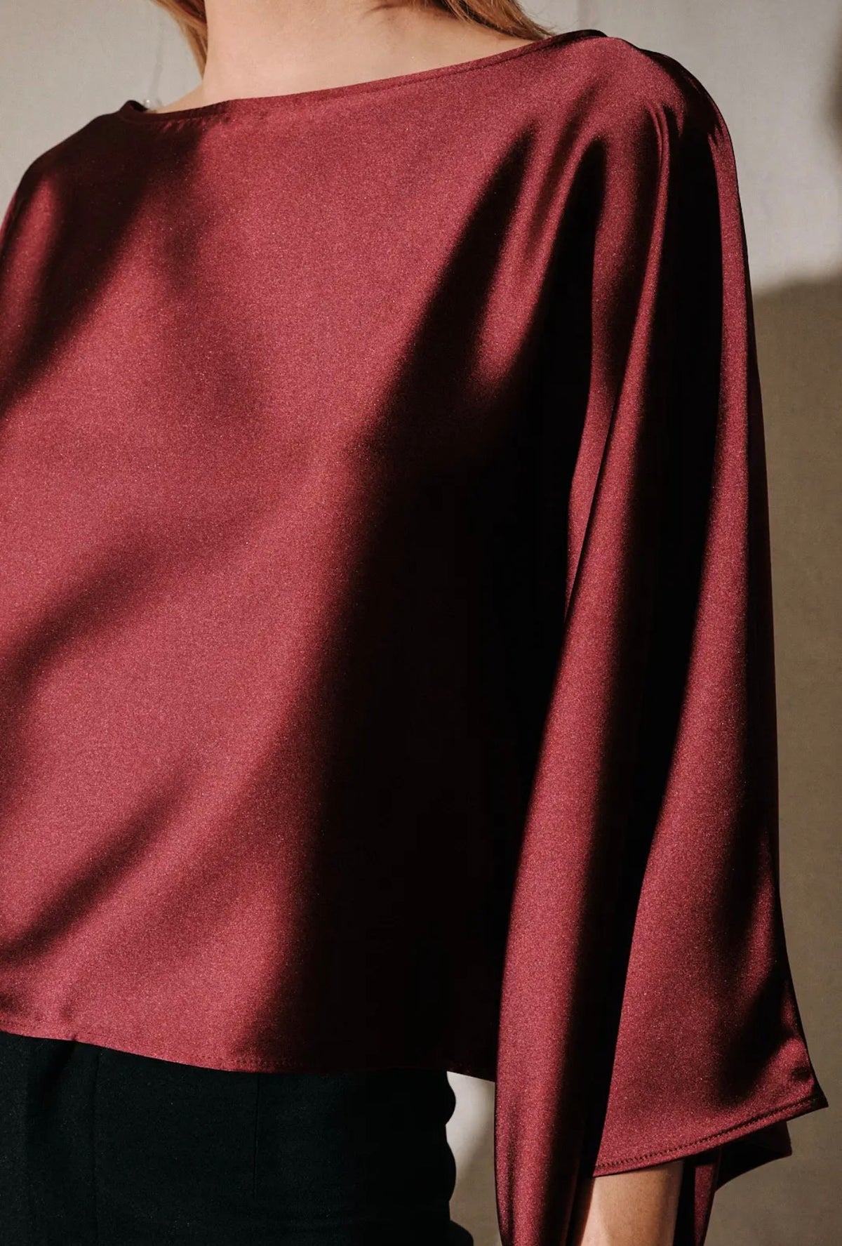 Burgundy satin boat-neck dolman poncho top, back view with draped 3/4 sleeves