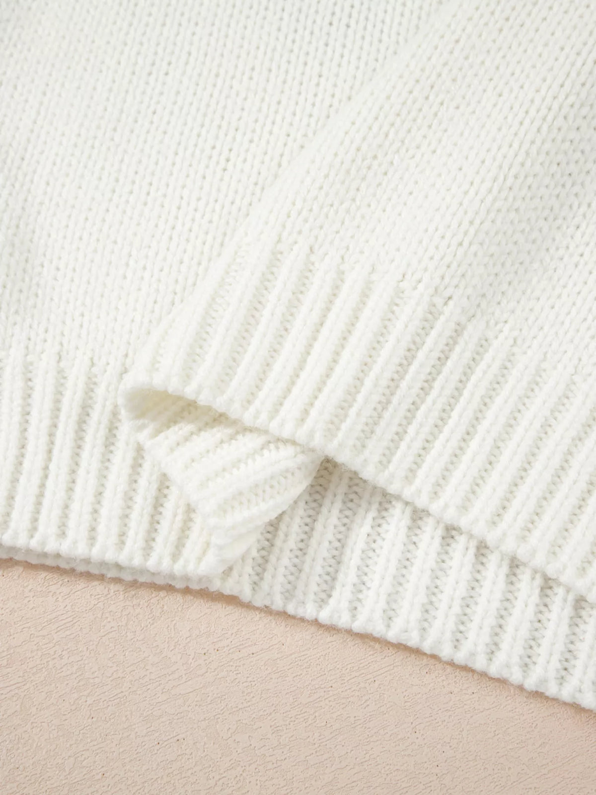 White ribbed knit sweater hem with textured knit body