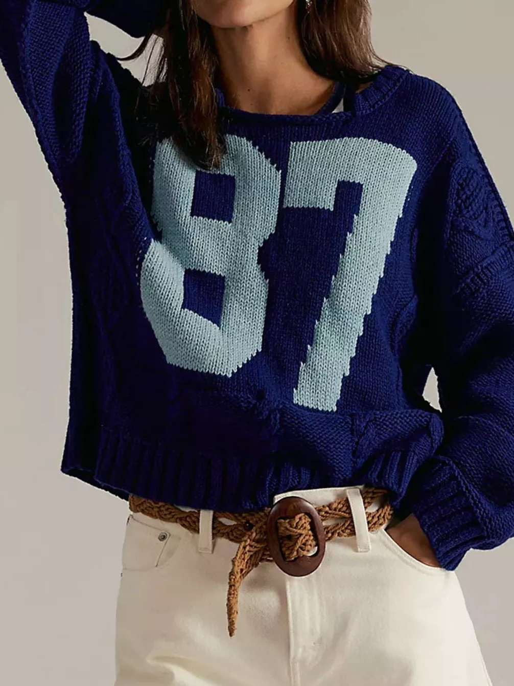 Dark blue cable-knit sweater with light 87 number graphic, ribbed hem and cuffs