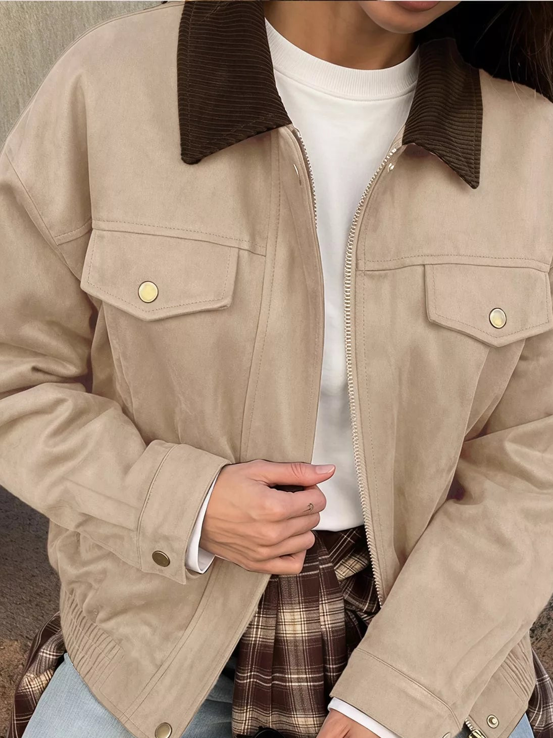 Apricot/beige zip jacket detail with dark collar, snap chest pockets, and gold buttons