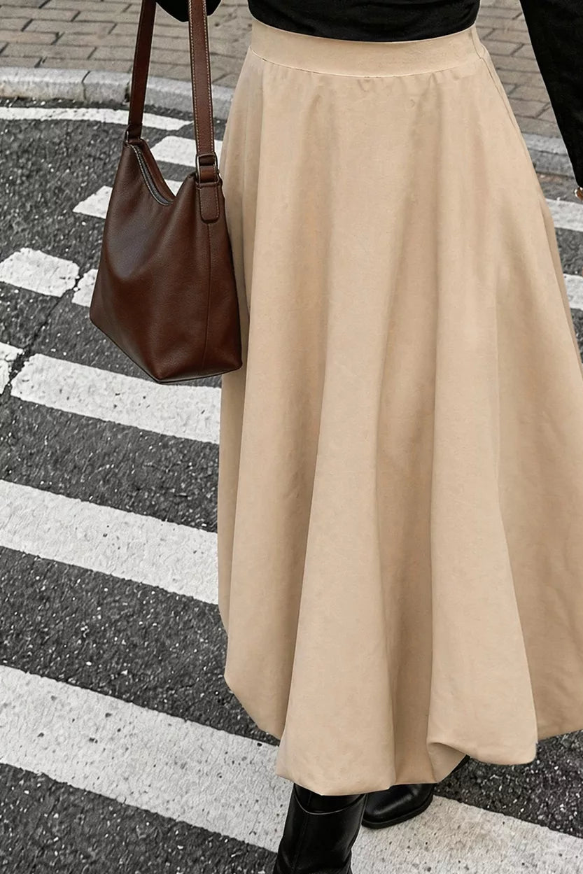 Tan midi skirt with a clean waistband and wide, flowing panels.