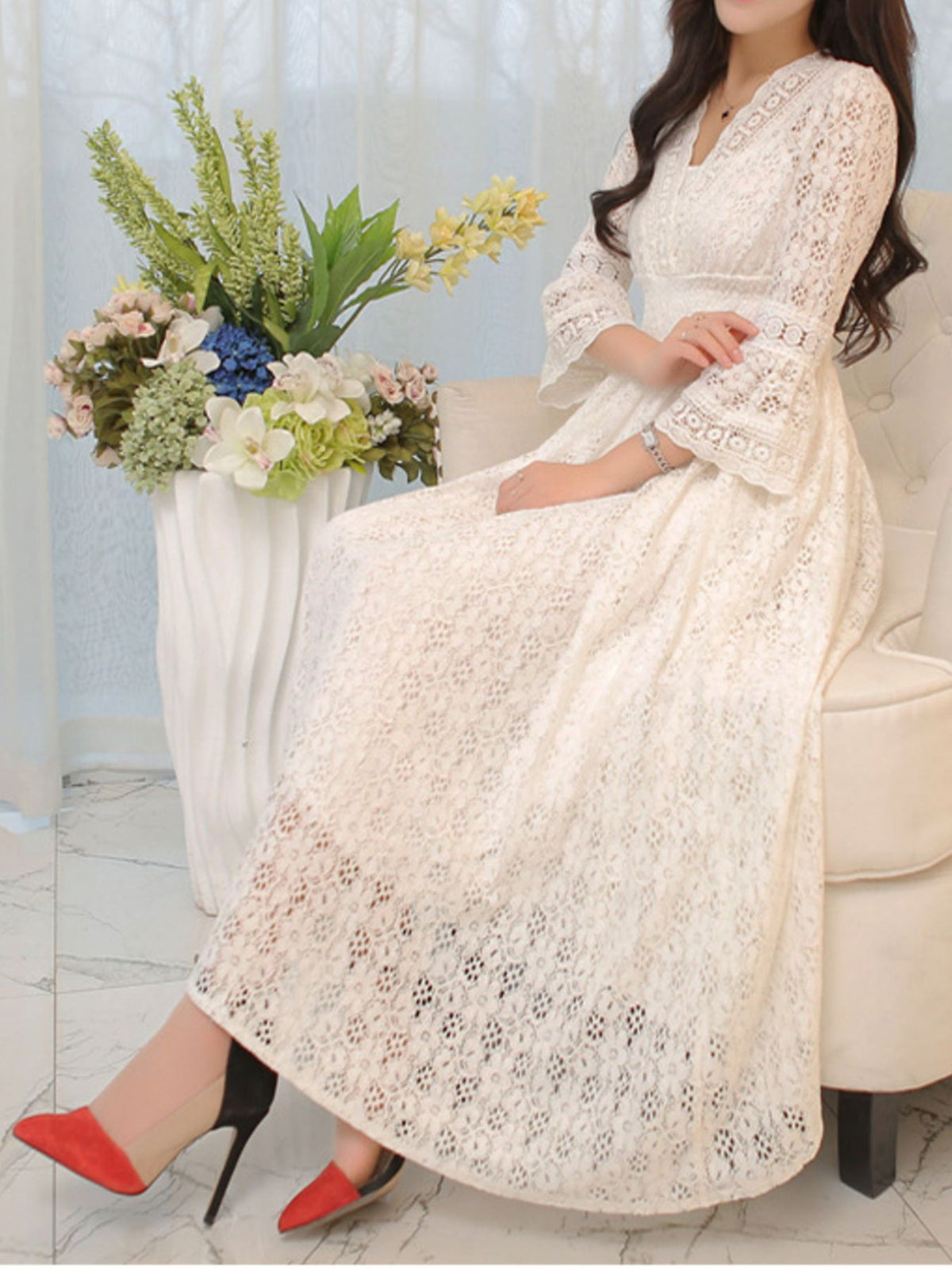 White lace midi dress with a V-neck, flared three-quarter sleeves, and a full skirt