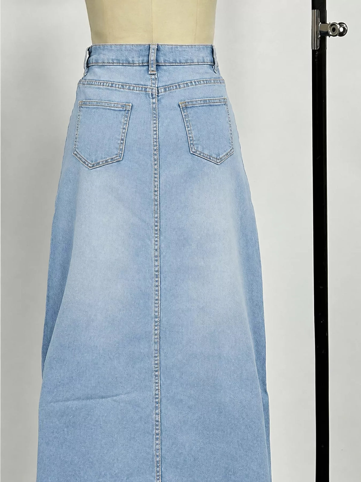Light blue denim maxi skirt back view with welt pockets and belt loops