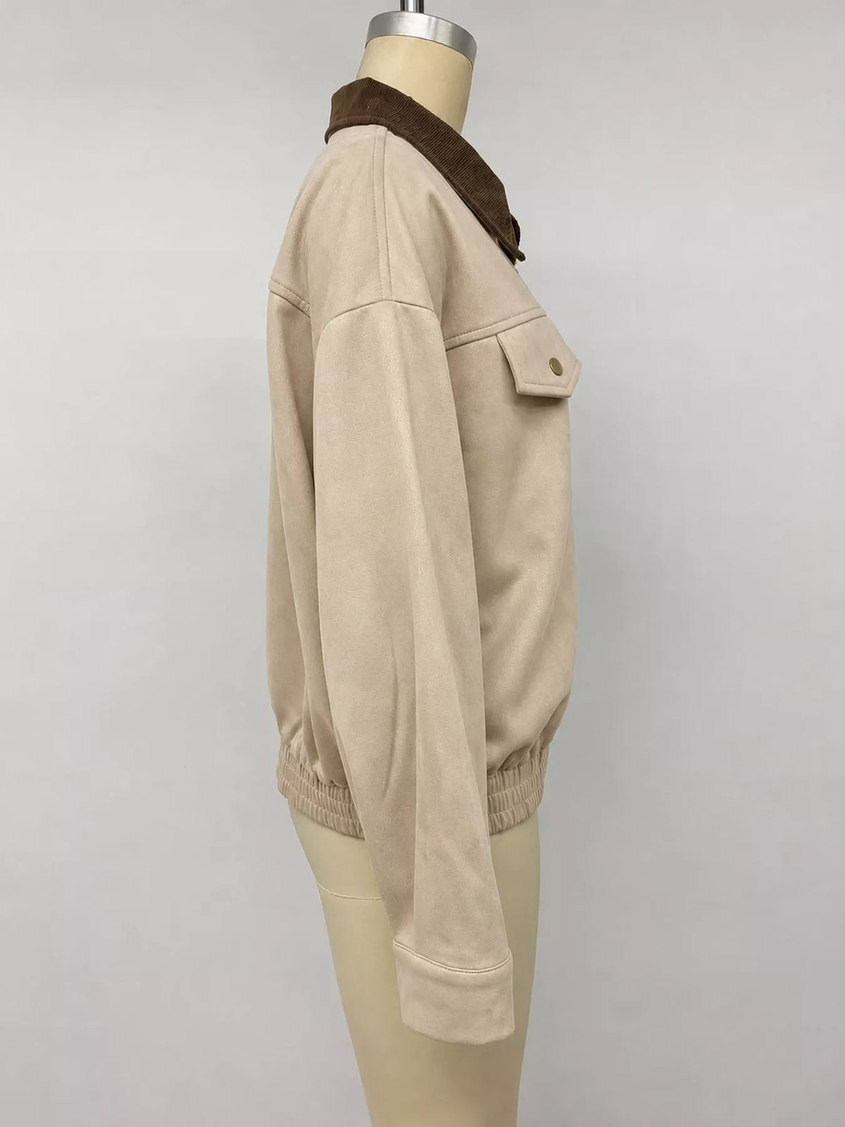 Apricot/beige zip-up jacket side view with dark collar trim and ribbed hem