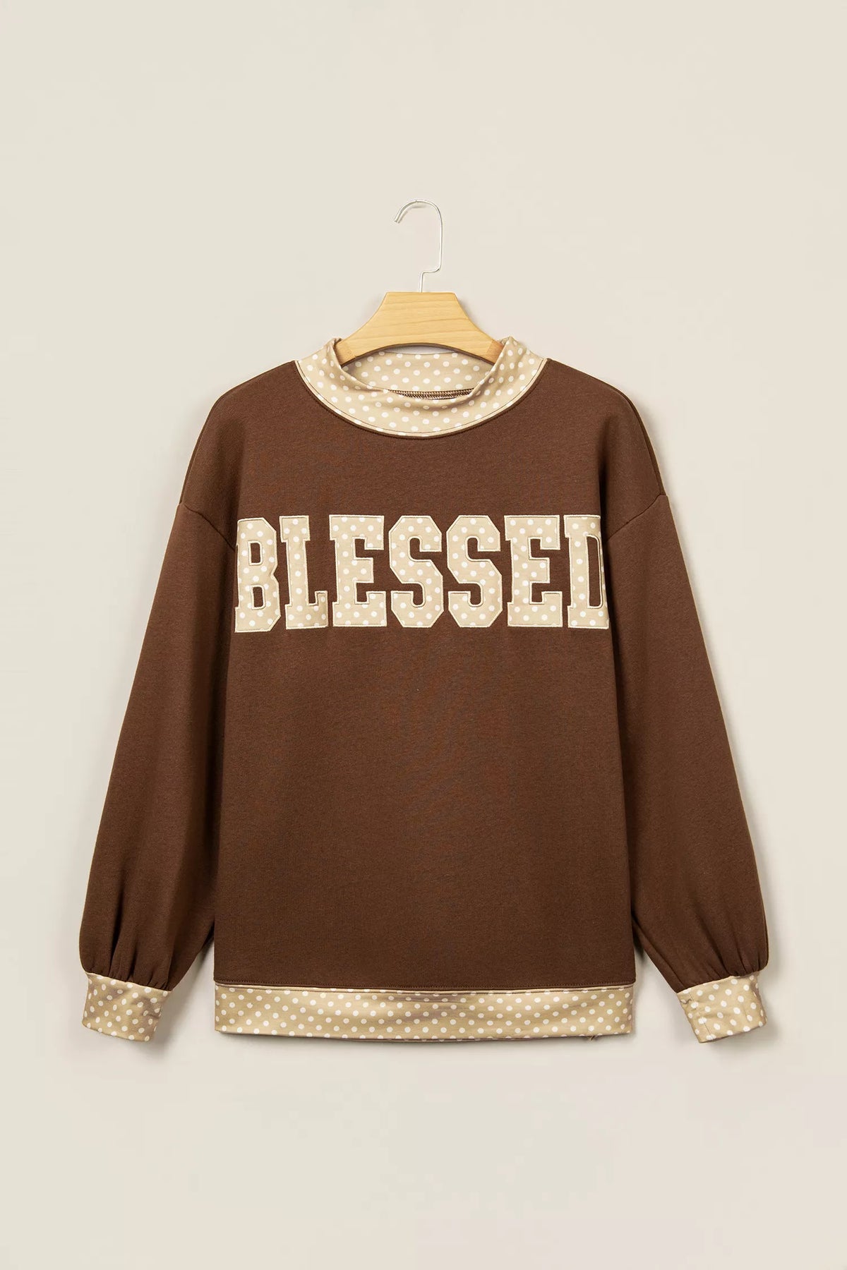 Dark brown sweatshirt with 'BLESSED' graphic, high neck, polka-dot cuff trim