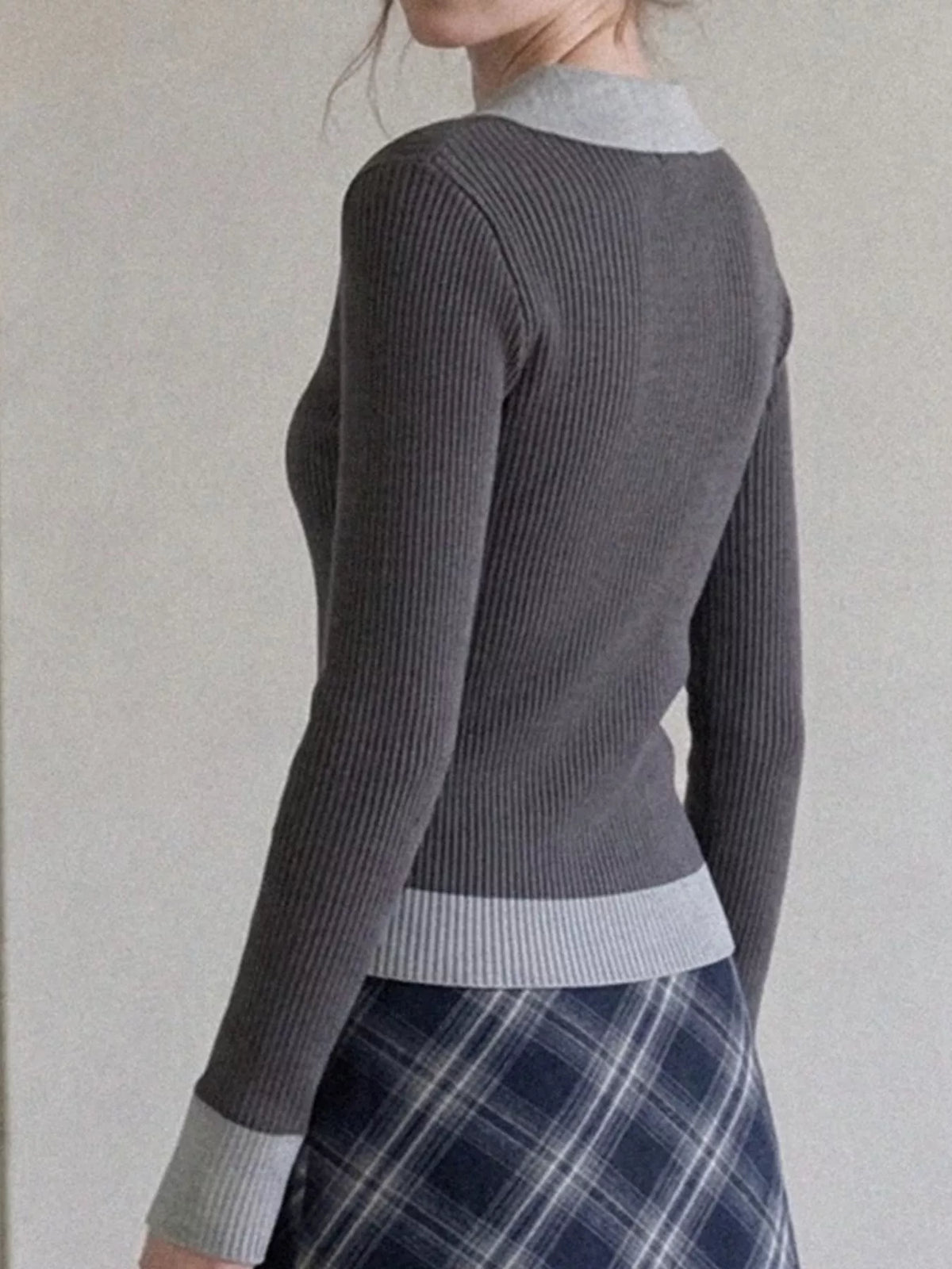 Back view of charcoal ribbed knit top with gray collar, cuffs, and hem