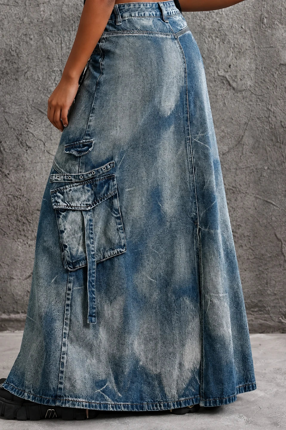 Blue high-waisted denim maxi skirt with front zipper slit, patch pockets, and button fly