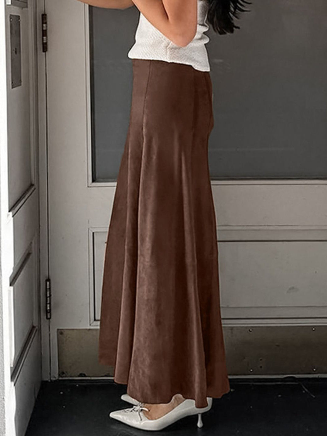 Side view showing the flared shape of the brown suede midi skirt