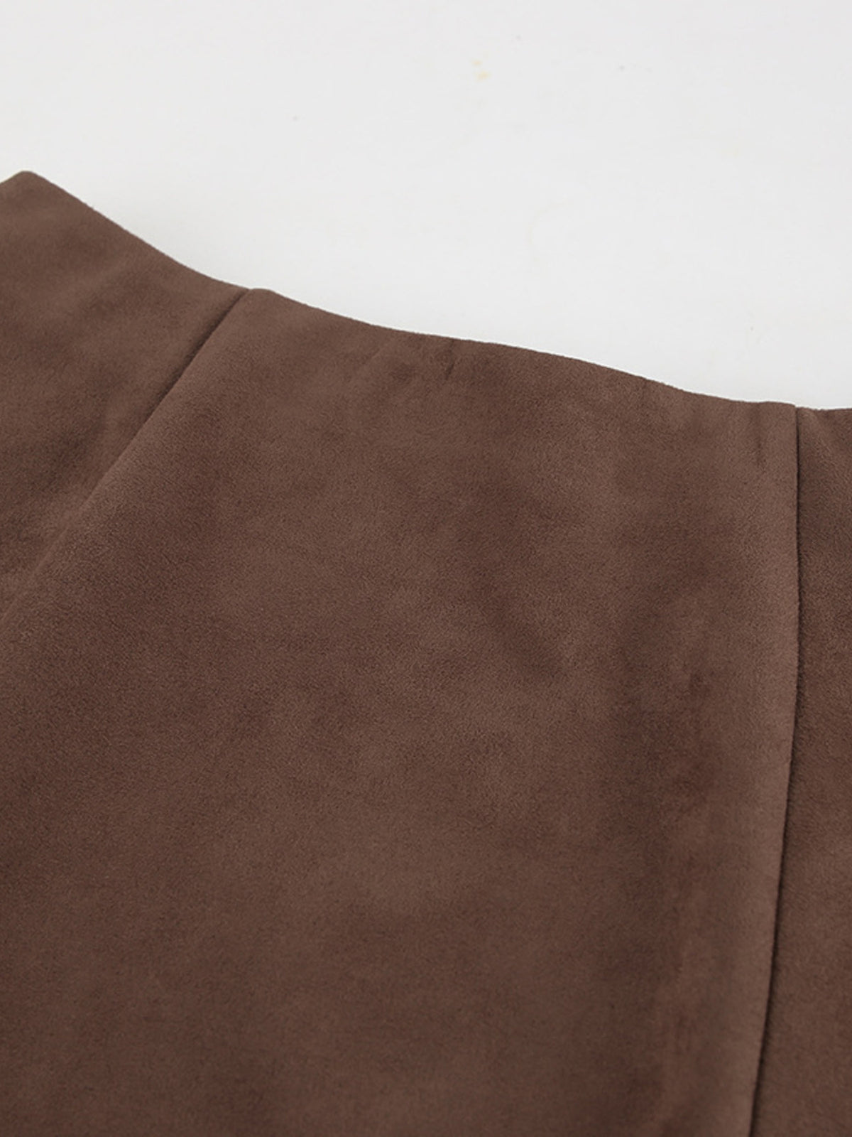 Close-up of the suede texture and panel seam on the midi skirt