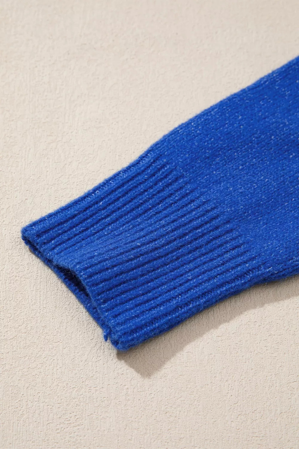 Royal blue ribbed knit sleeve cuff, knit texture close-up