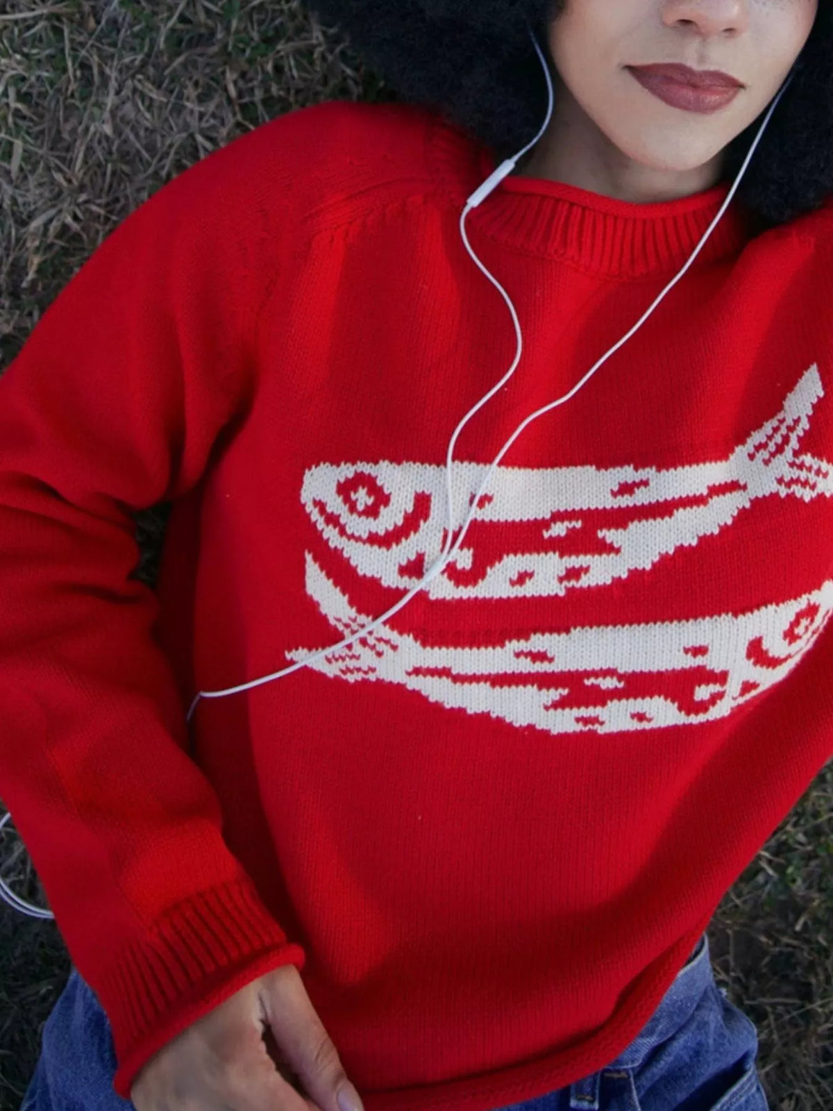 Red crew neck sweater with white fish pattern on chest and ribbed collar