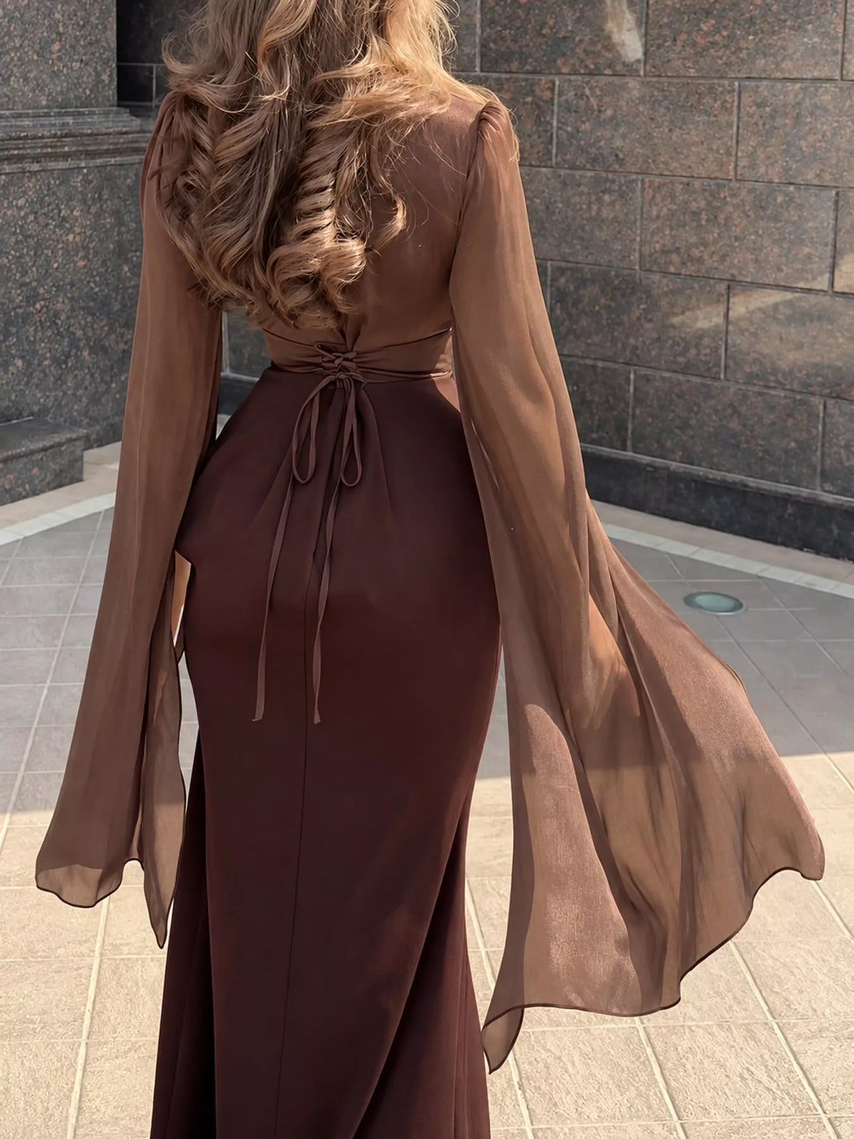 Back of the two-tone maxi dress with a waist tie and sheer flared sleeves