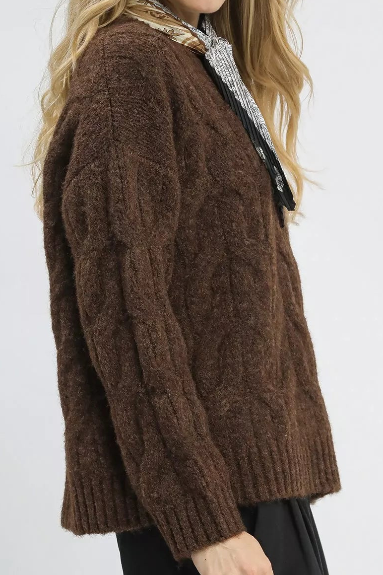 Brown cable-knit sweater with textured knit pattern and long sleeves, side view