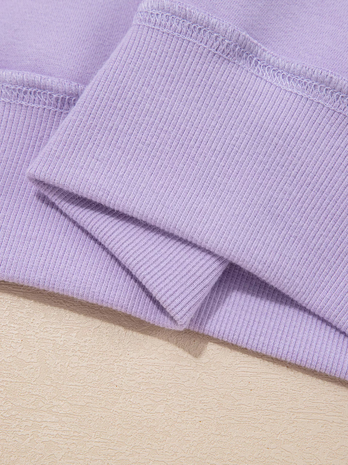 Lavender ribbed cuff and stitched hem detail on sweatshirt