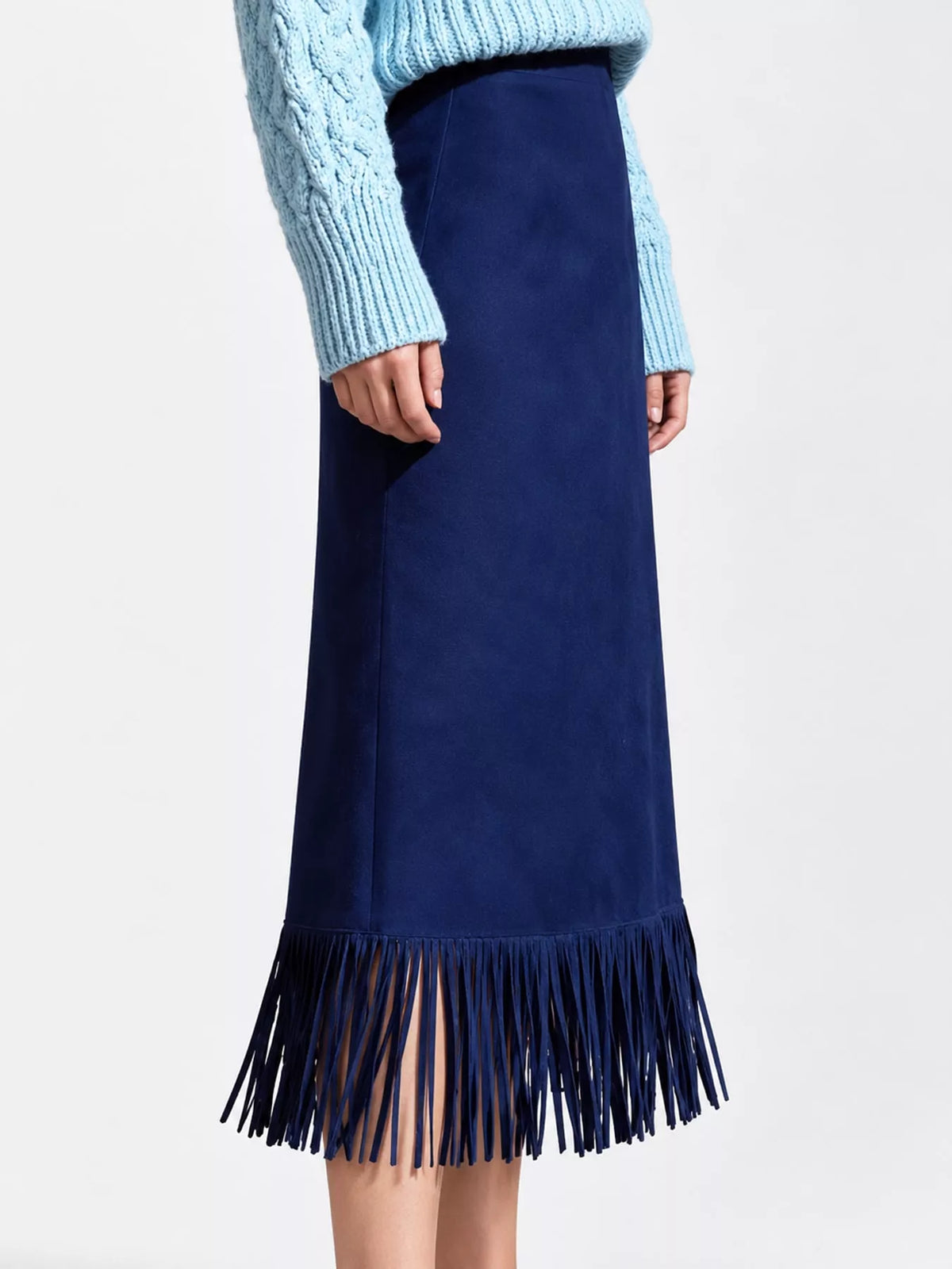 Dark blue high-waisted midi skirt with long fringe hem, shown on a model from the front.