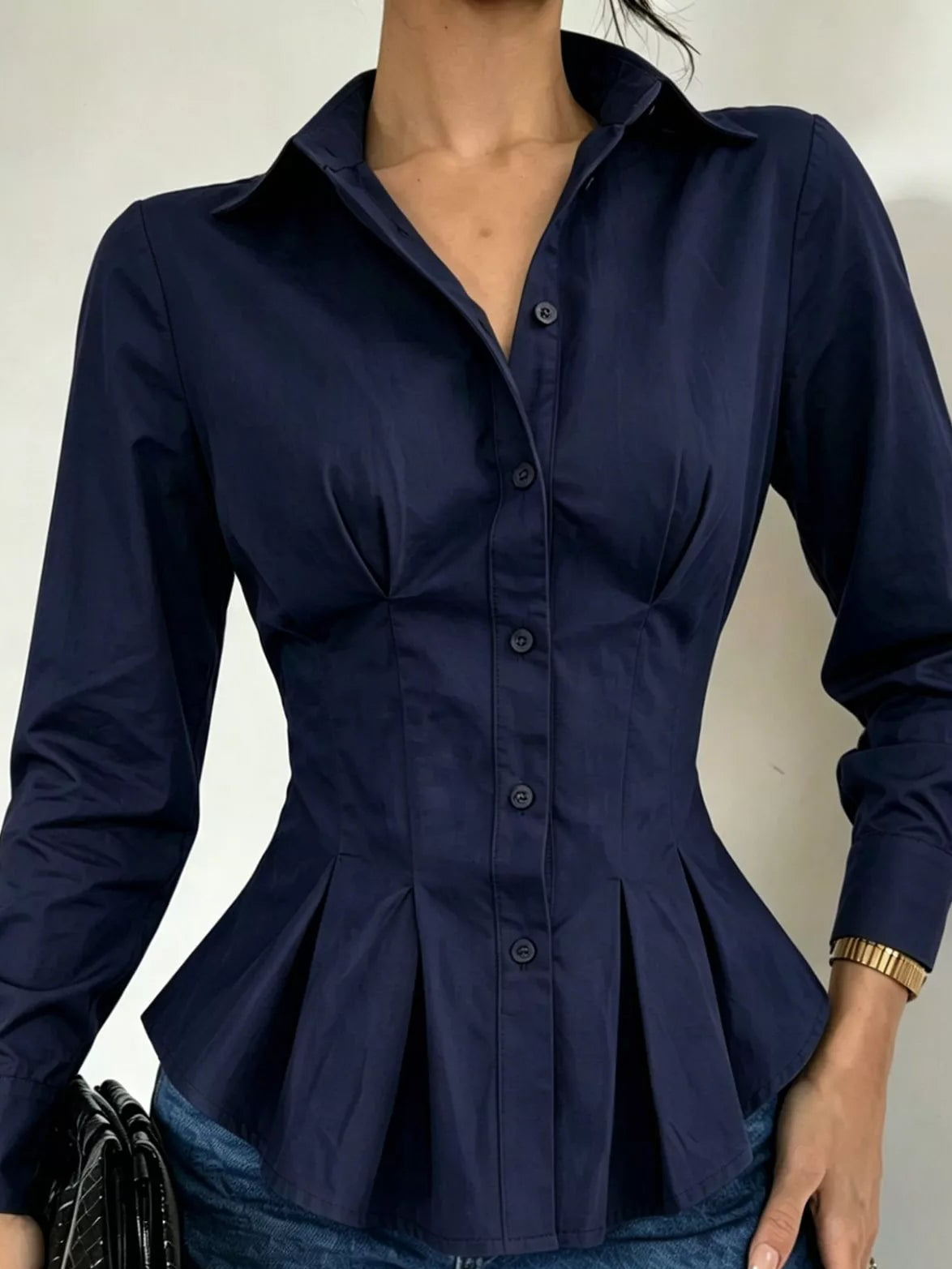 Navy button-down peplum blouse with fitted waist, long sleeves, structured peplum hem