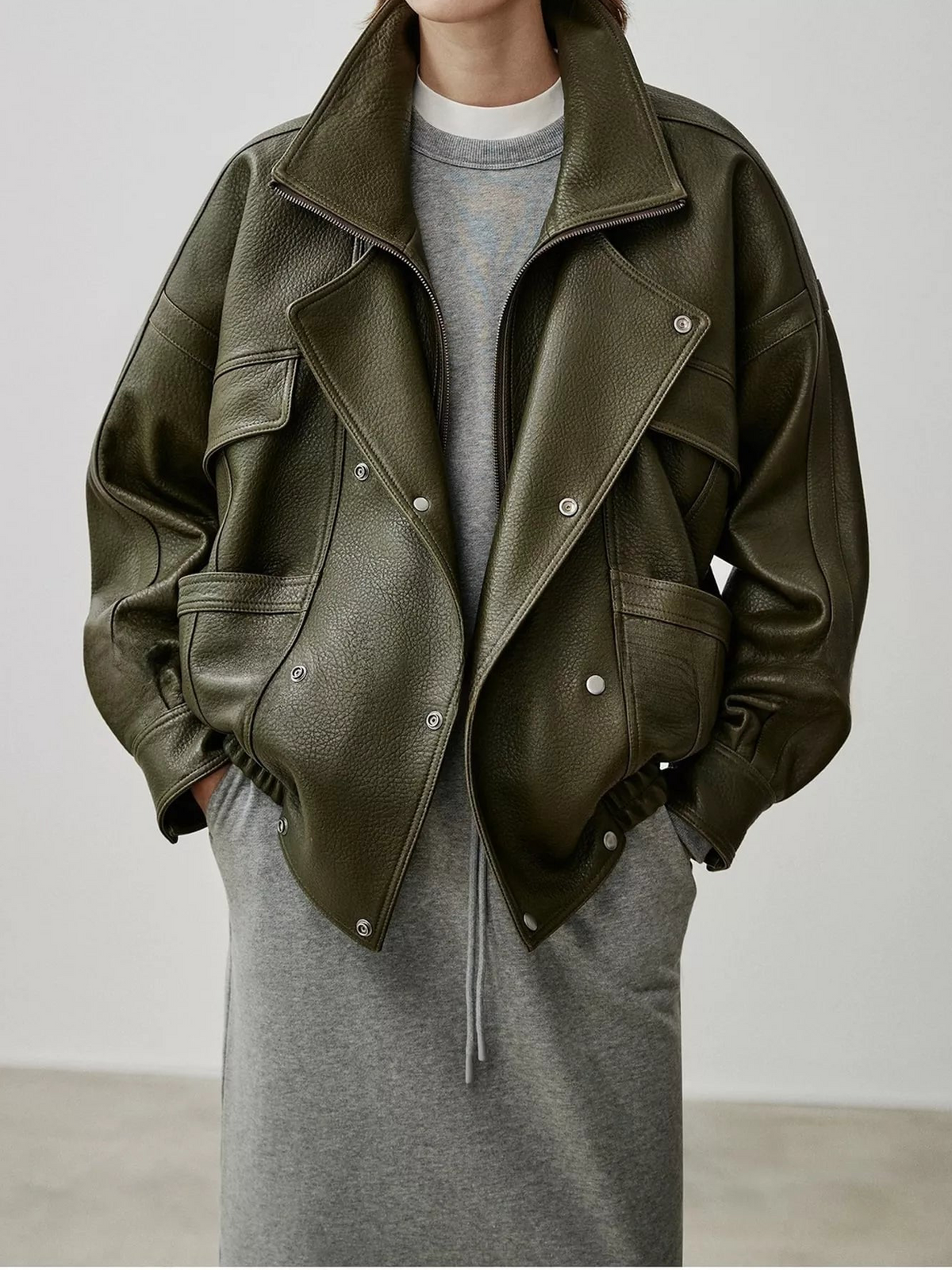 Dark green leather down jacket with flap panels, snap buttons, and ribbed cuffs