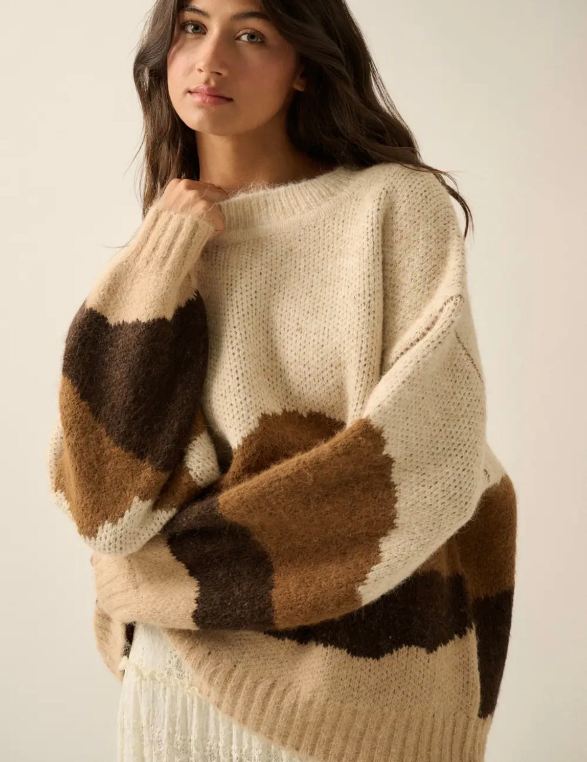 Fuzzy crewneck sweater with cream body and brown landscape block pattern at sleeves