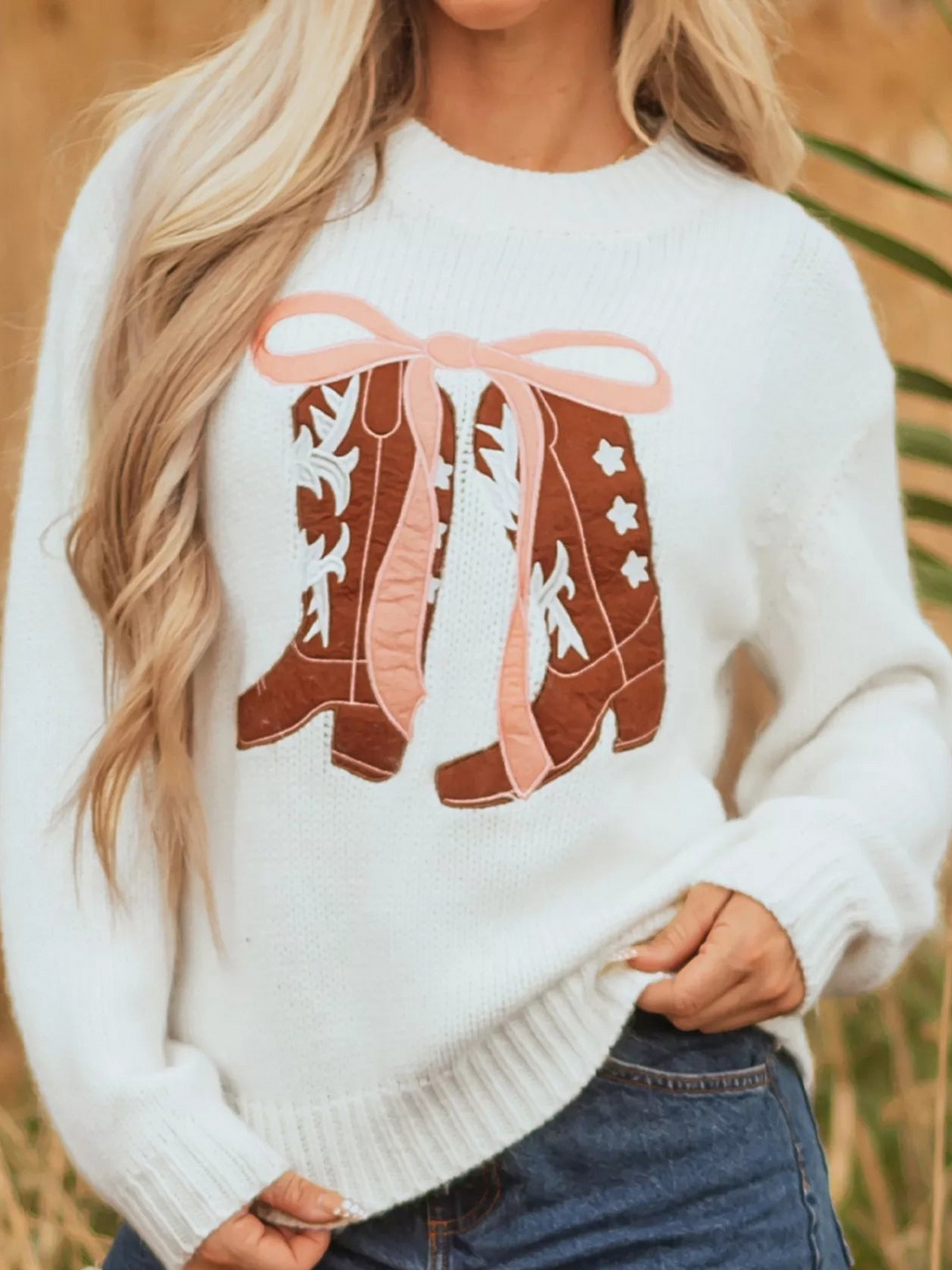 White knit sweater with embroidered bow boots graphic on the chest