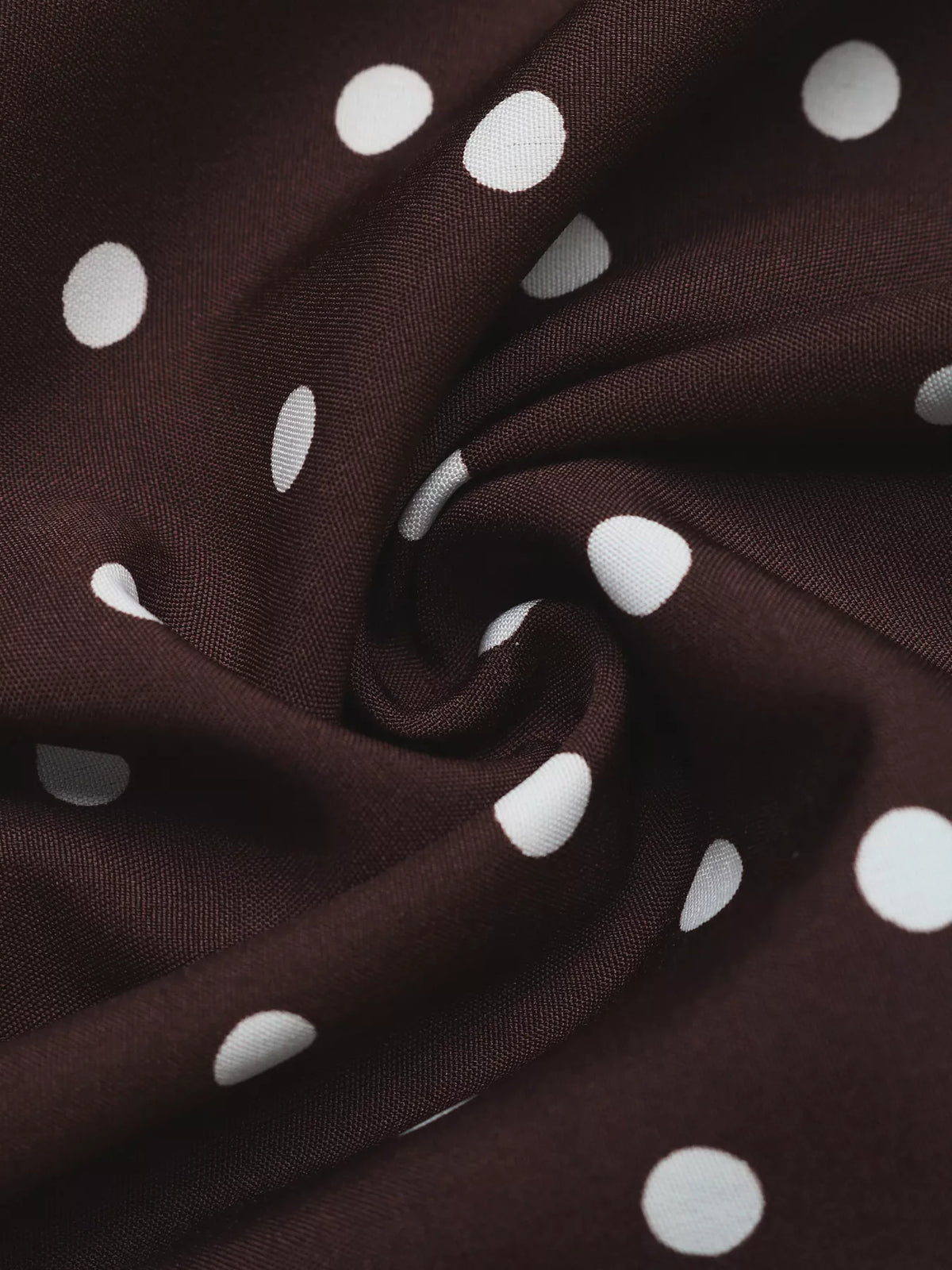 Woven texture close-up of coffee brown dress fabric with white polka dots