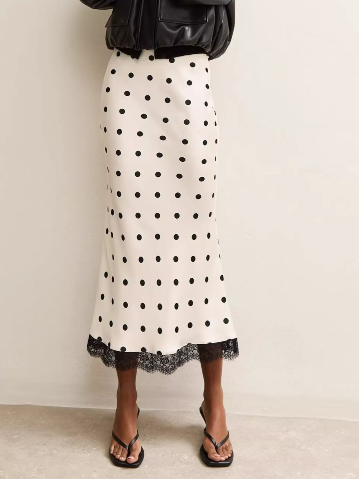 White midi skirt with black polka dots and lace hem, shown from the front.