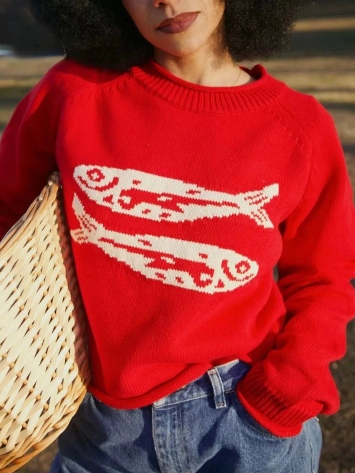 Red crew neck knit sweater with white fish graphic across chest