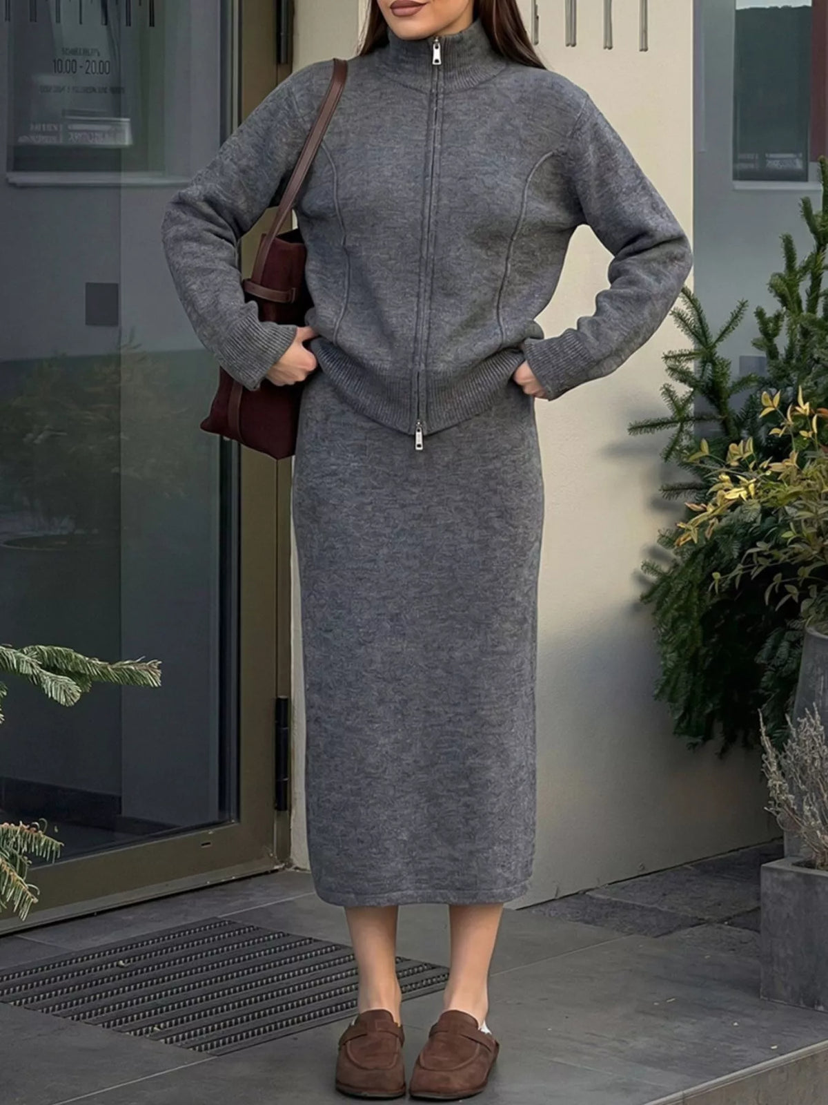 Dark gray cardigan and midi skirt set, cardigan worn zipped with hands at the waist