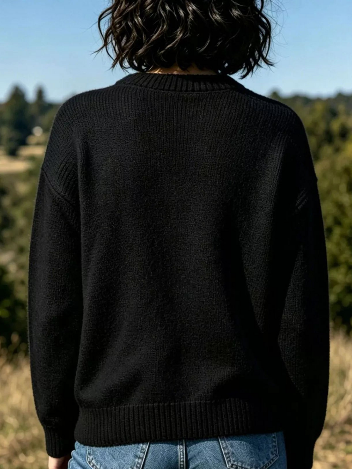Black crew neck sweater, back view with plain knit design