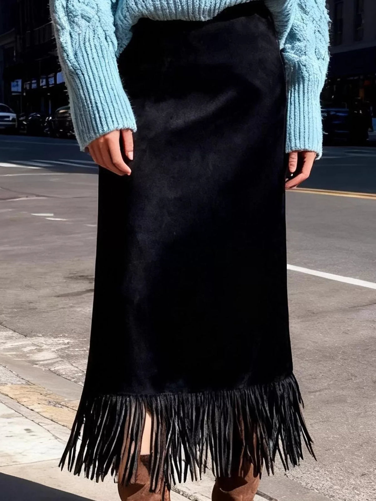 Black high-waisted midi skirt with long fringe hem, worn