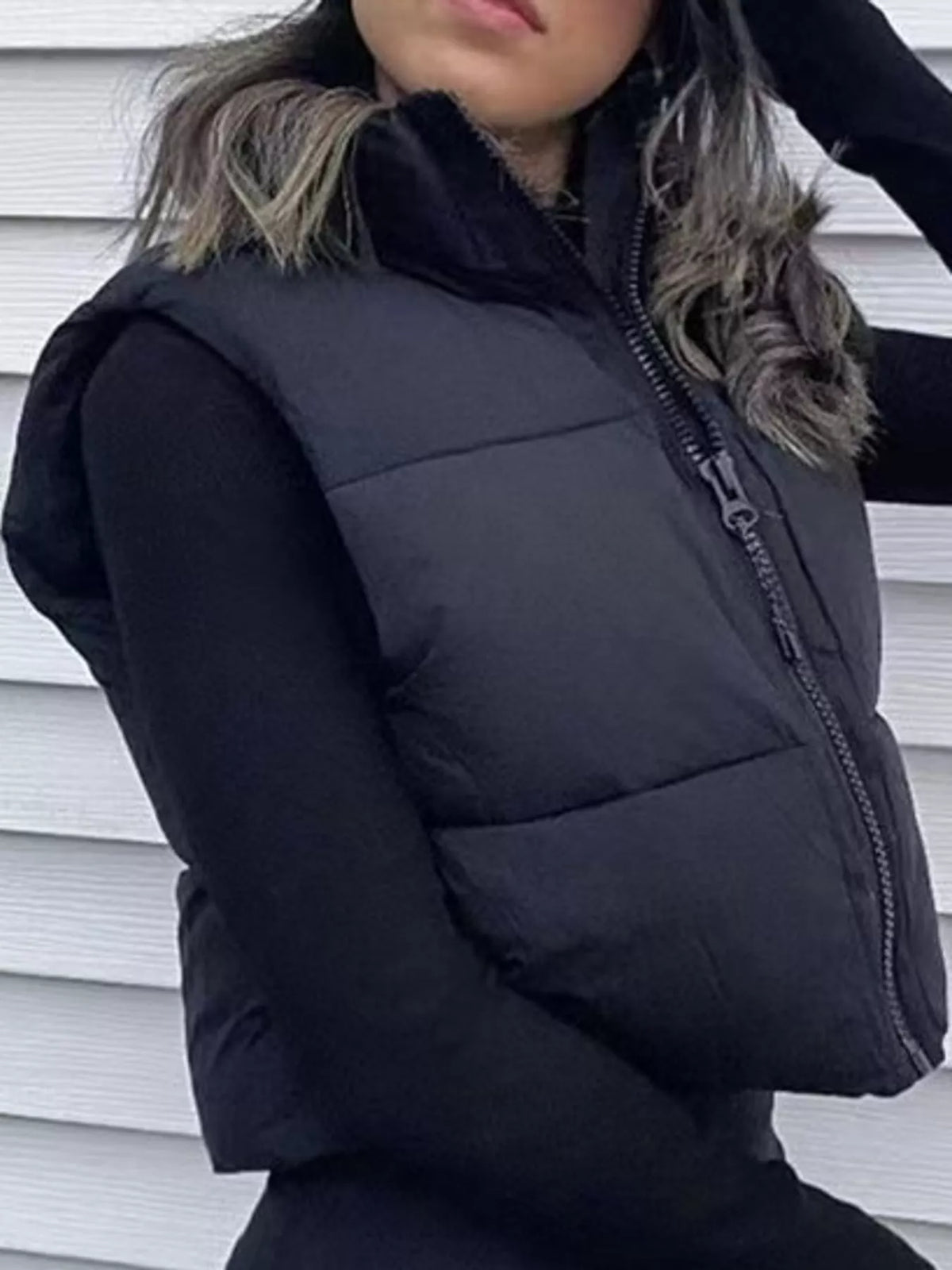 Black zip-up puffer vest with stand collar and quilted chest panels, sleeveless