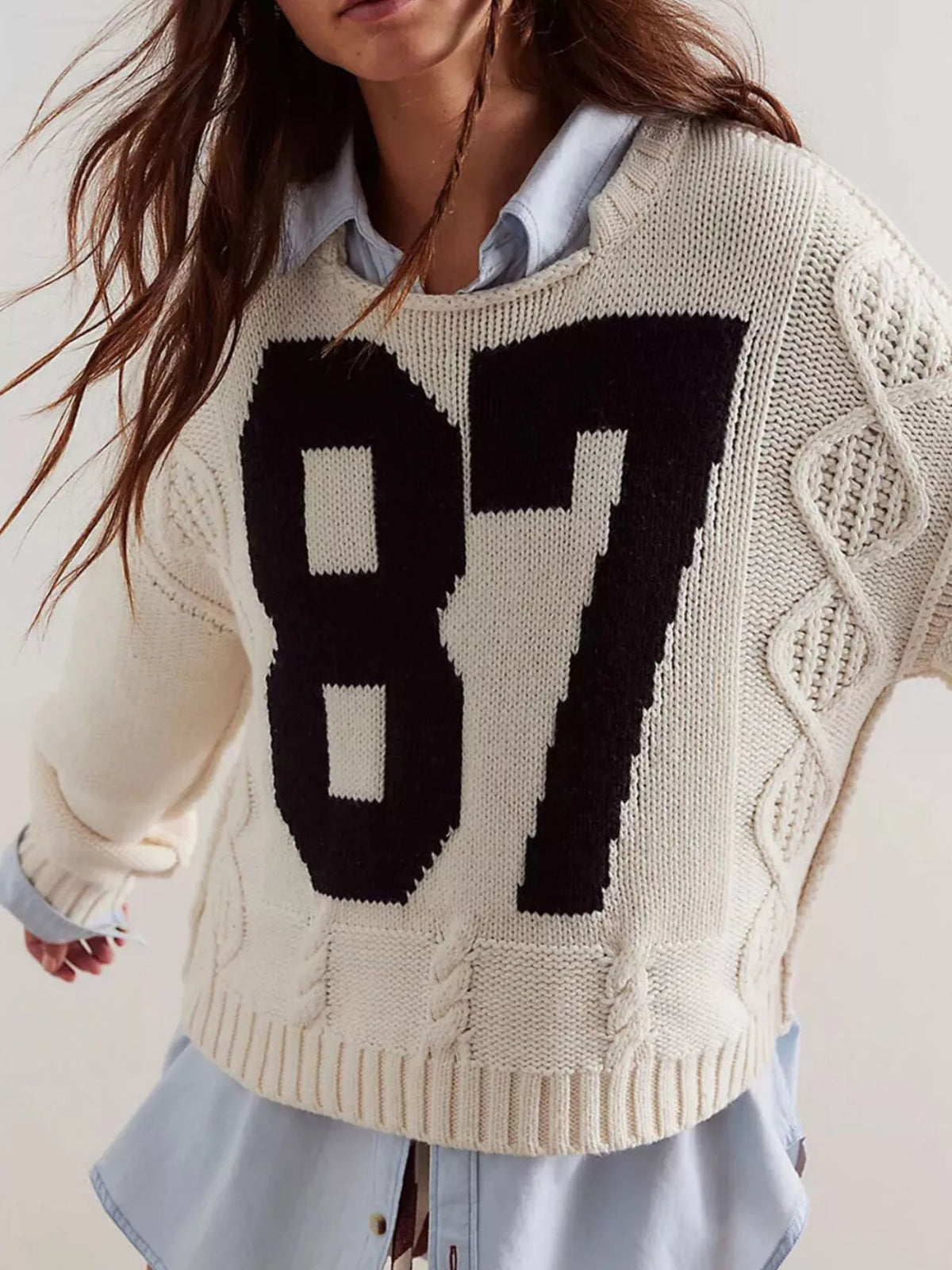 Off-white cable-knit sweater with large black 87 number graphic, crew neck