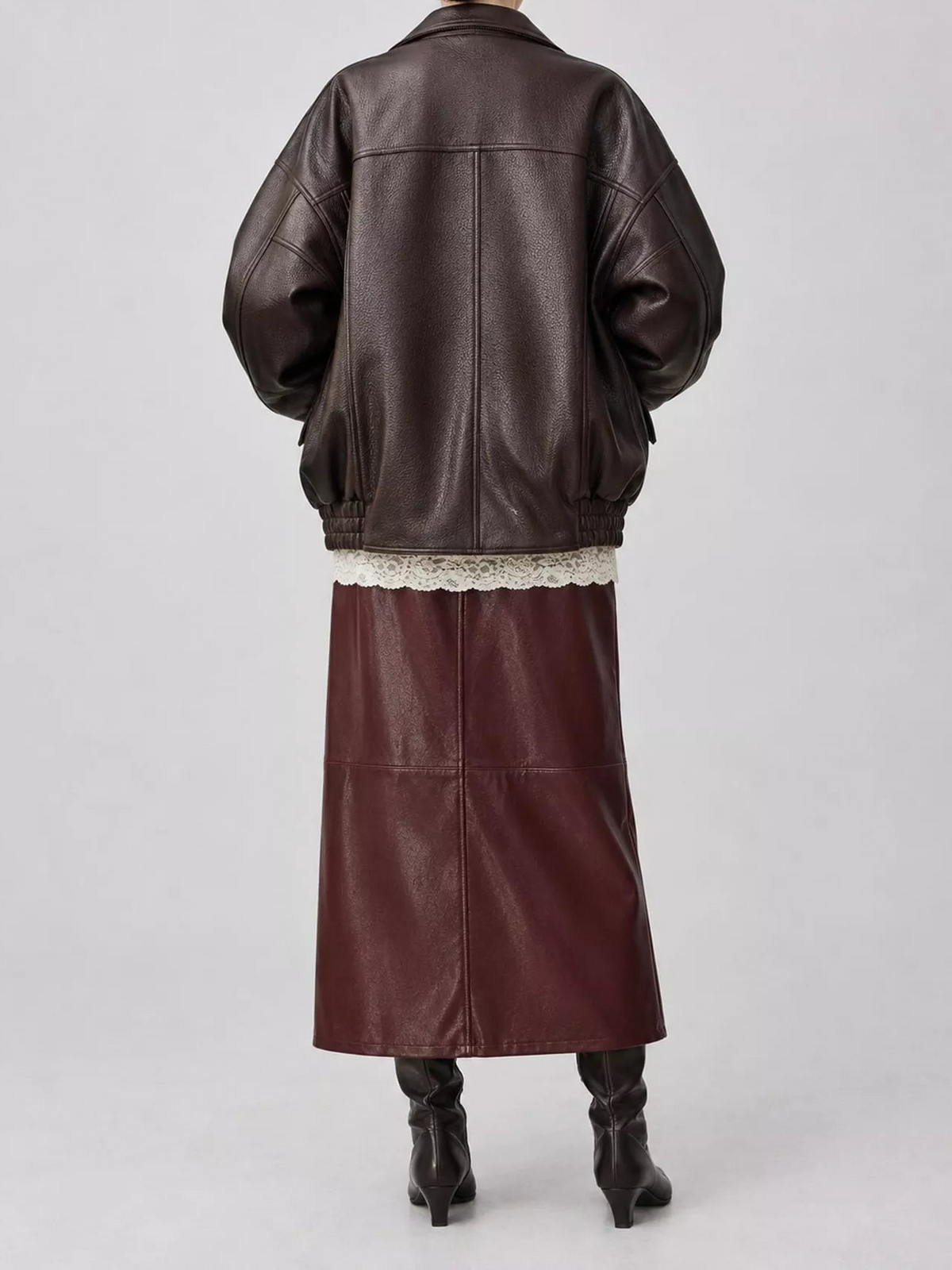 Dark brown leather jacket with shearling hem and ribbed knit cuffs, back view