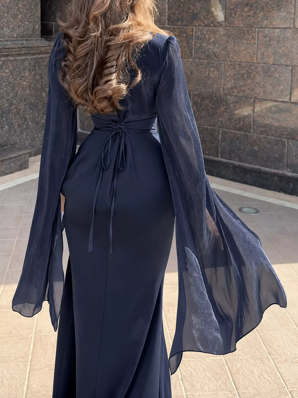 Dark blue maxi dress, back view, with waist ties and sheer flared sleeves