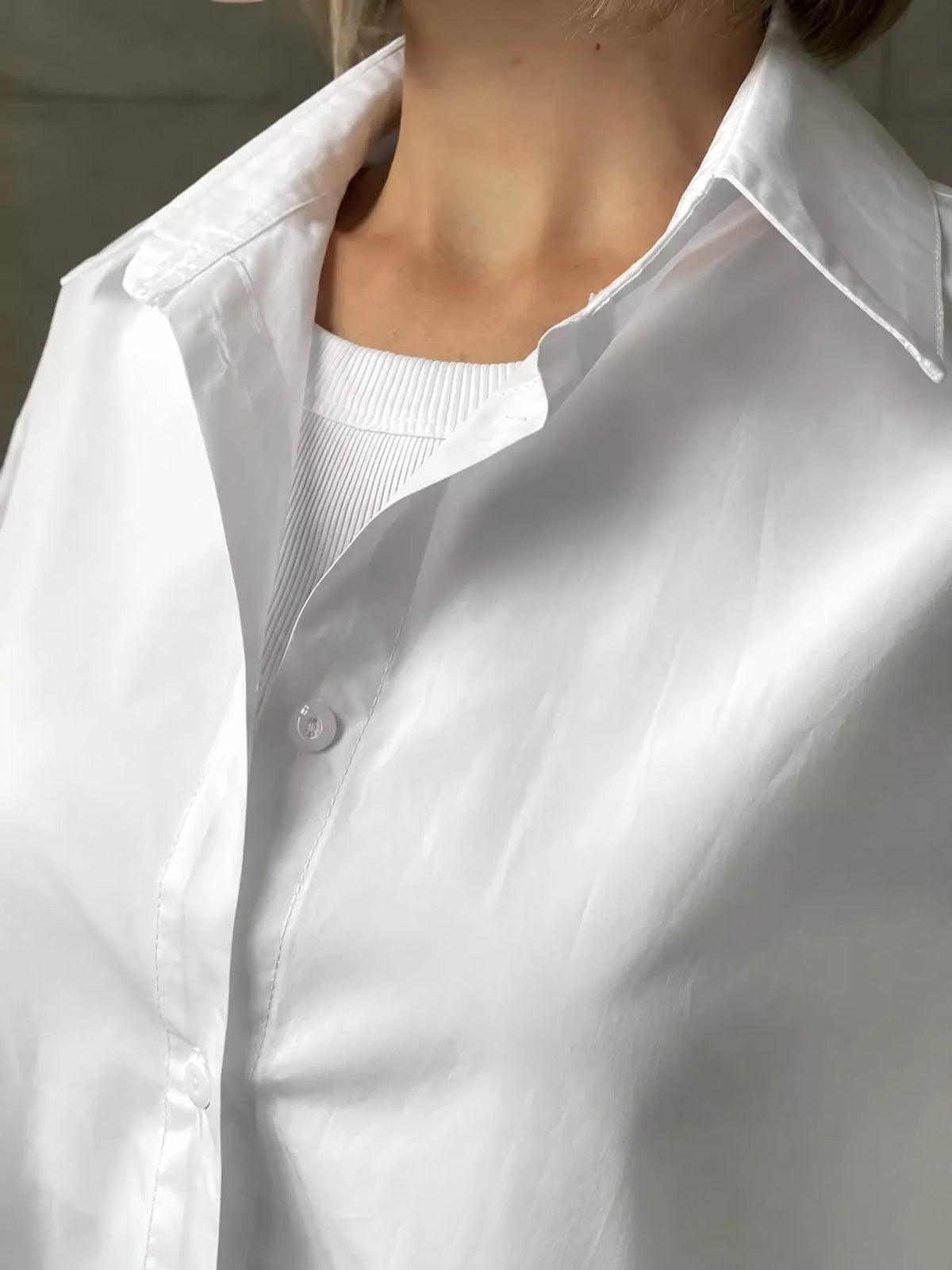 White button-up long sleeve shirt with open collar and round buttons