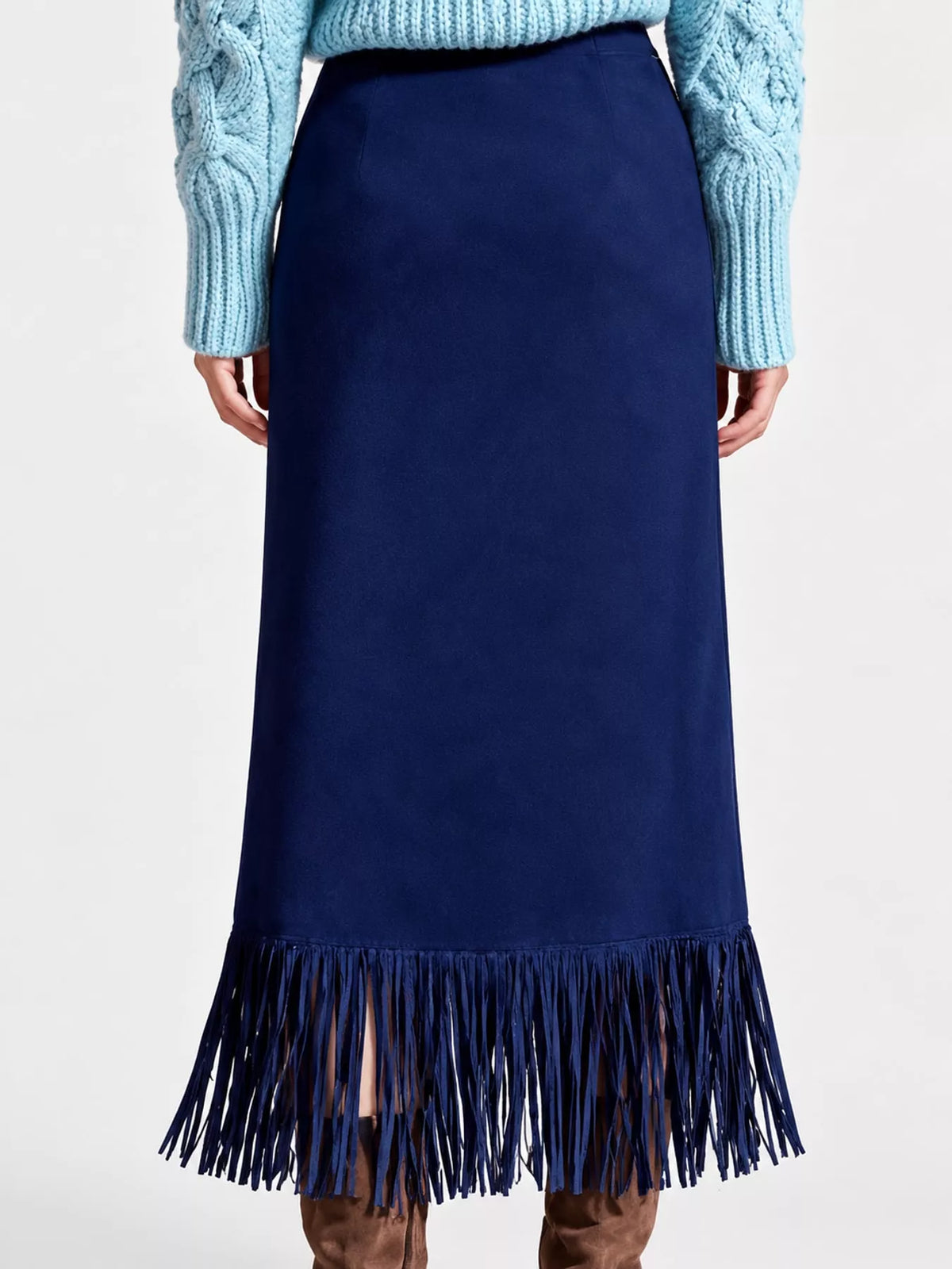 Dark blue high-waisted midi skirt with fringe hem, shown from the back on a model.