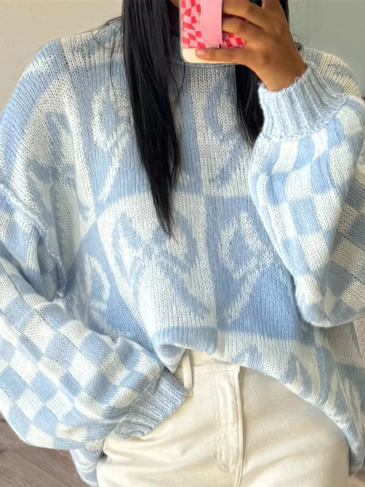 Light blue knit sweater with white checkerboard bow pattern and dropped shoulders