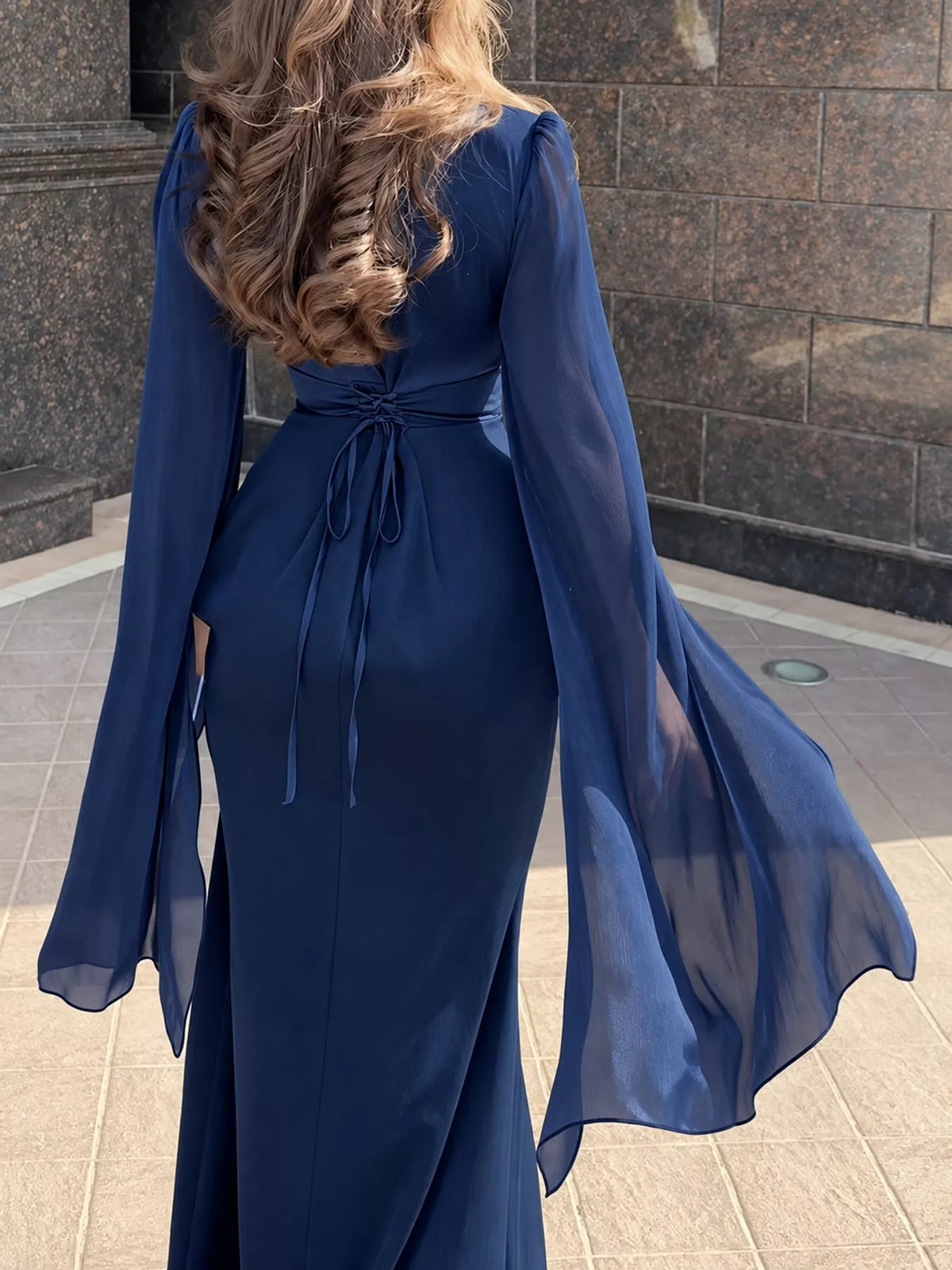 Dark blue maxi dress with a tied back waist and sheer flare sleeves