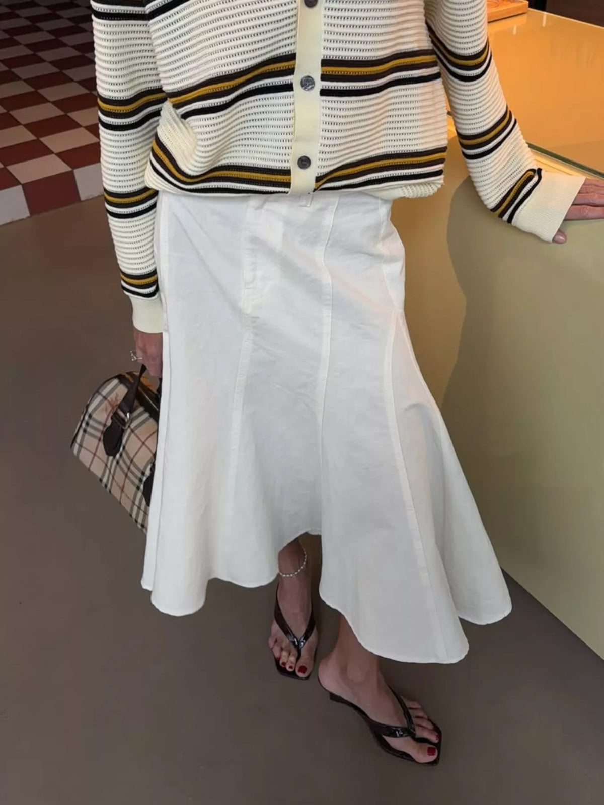 White mermaid midi skirt with a high waist and panel seams, worn from the front