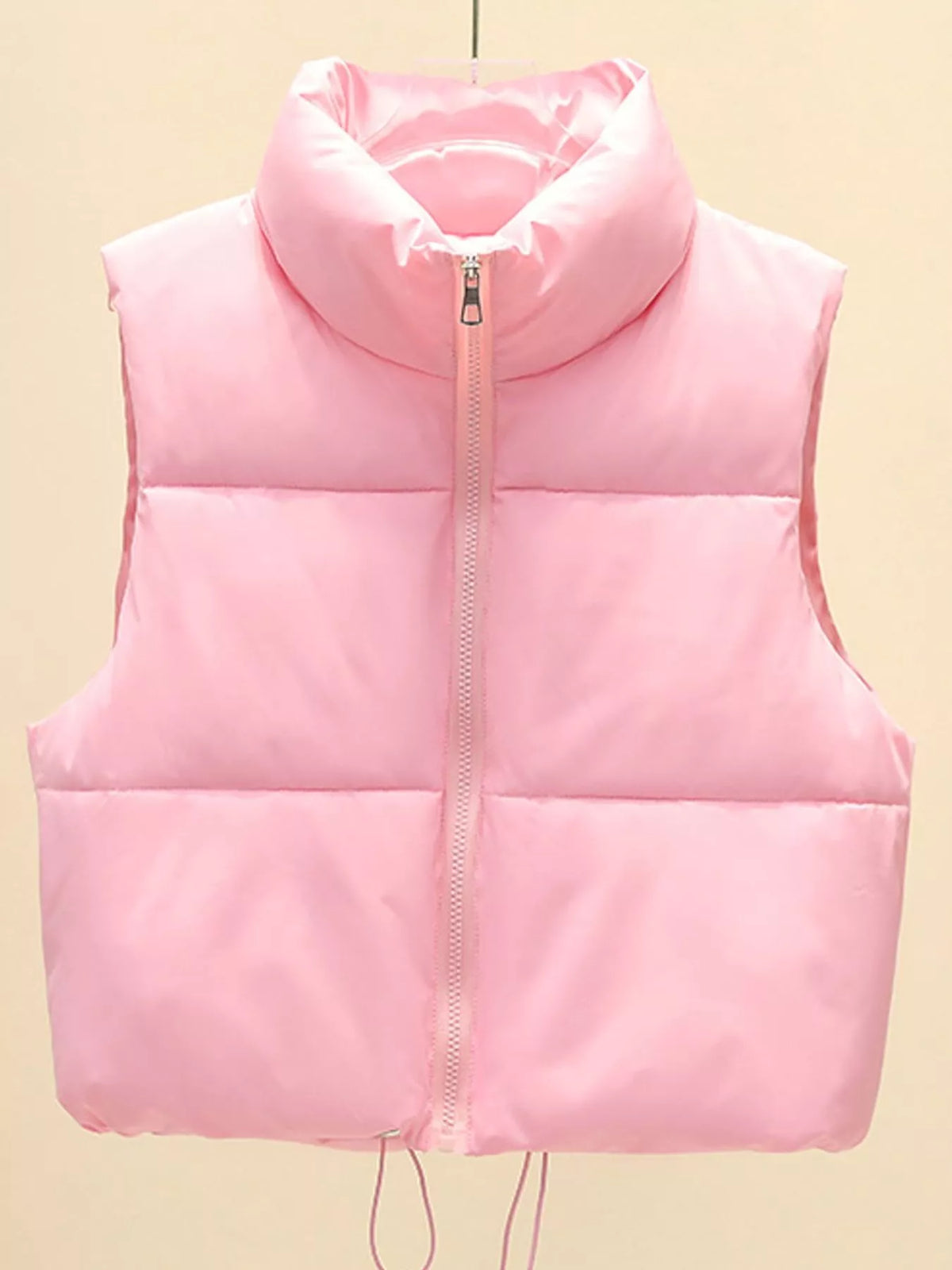 Light pink zip-up puffer vest with stand collar, quilted front panels, sleeveless