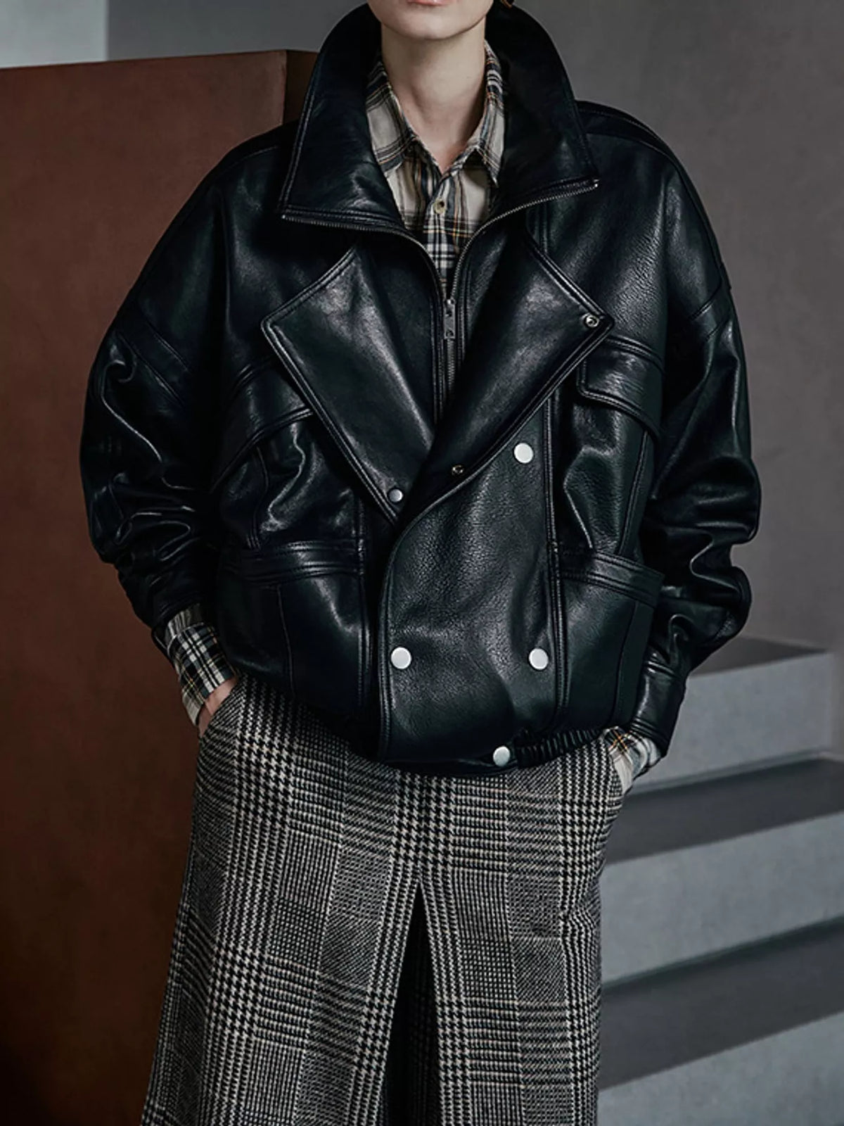 Black leather jacket with wide lapels and buttoned flap pockets, front view