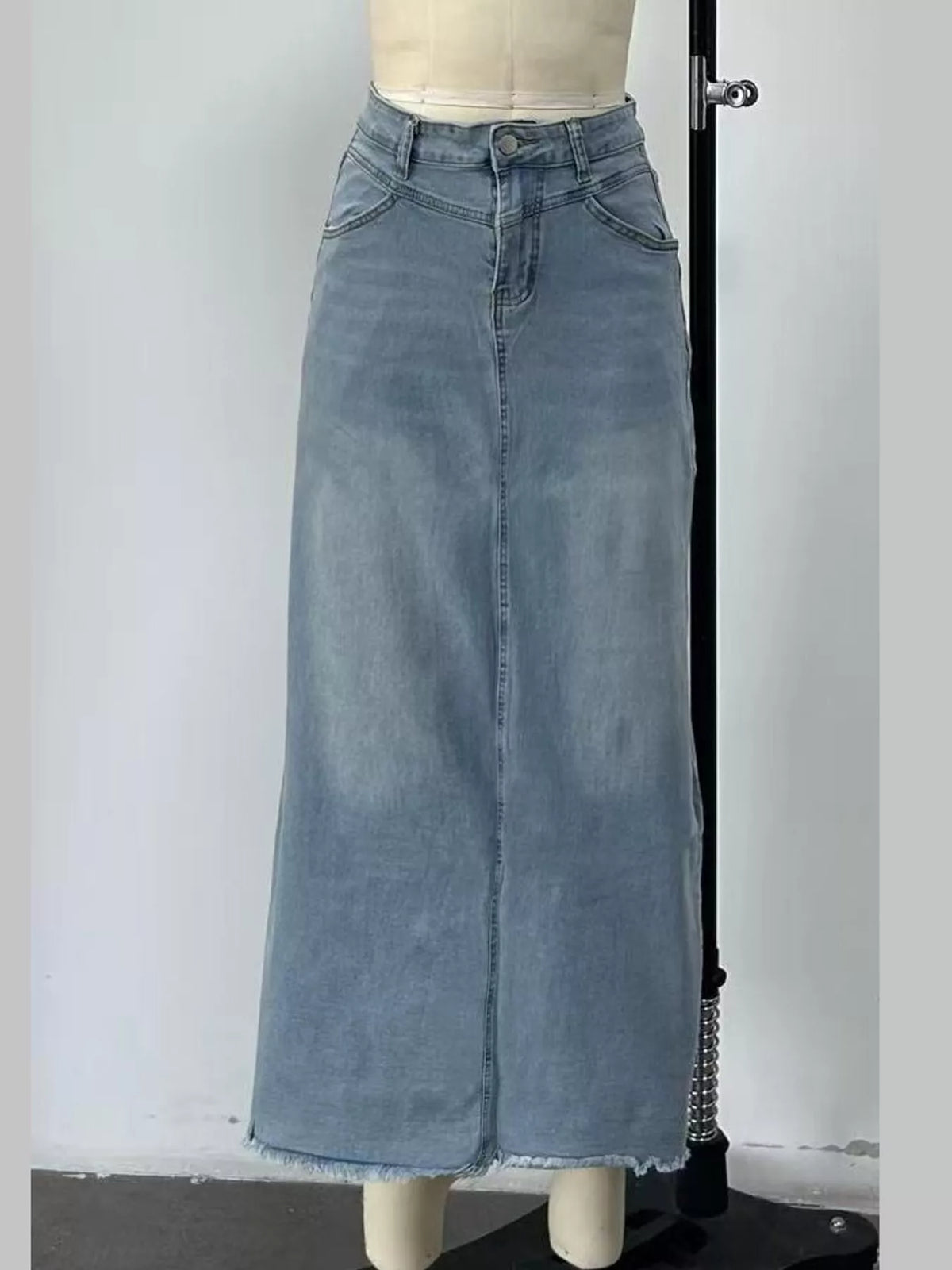 Light blue denim maxi skirt front with raw hem and back-to-front seam panel