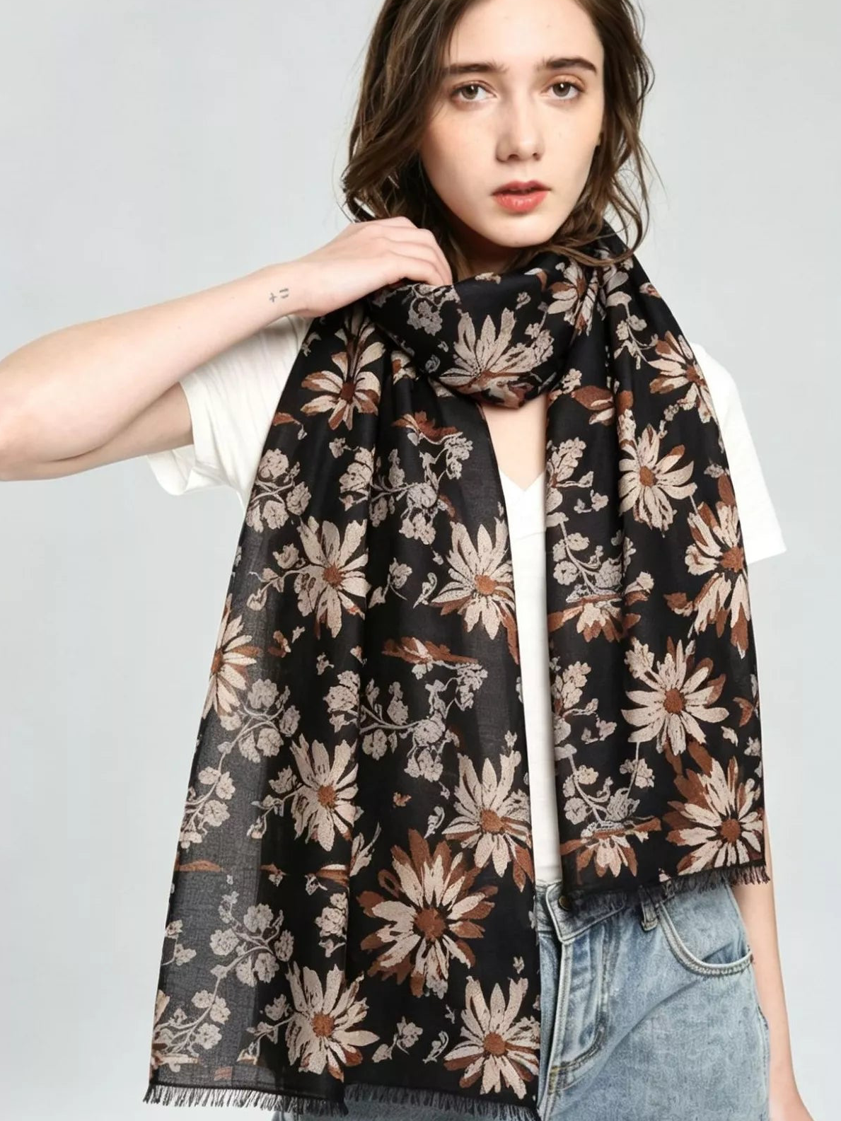 Floral print scarf draped around neck, dark base with large tan and cream blossoms
