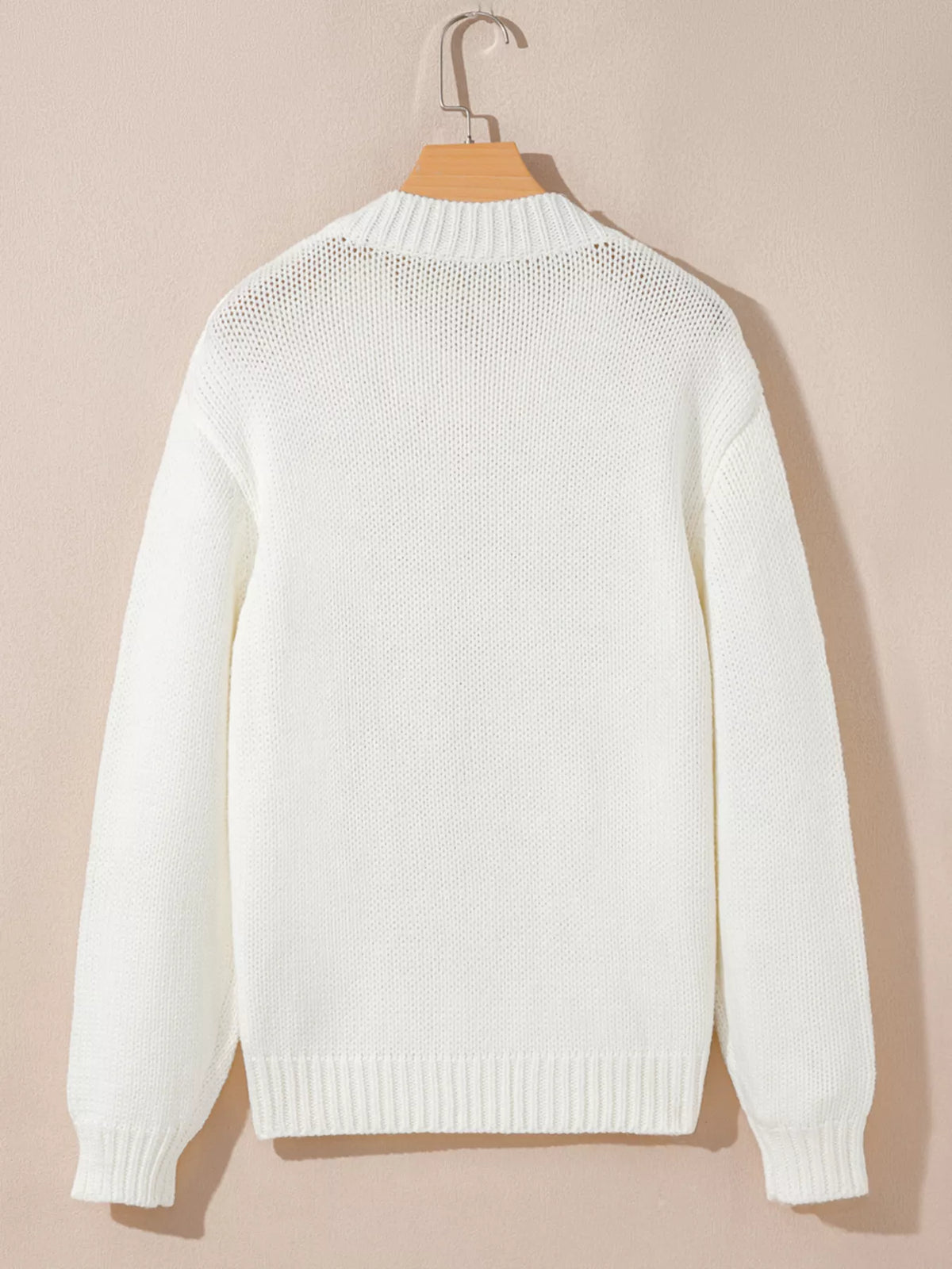 White knit sweater on a hanger, back view with ribbed hem and cuffs