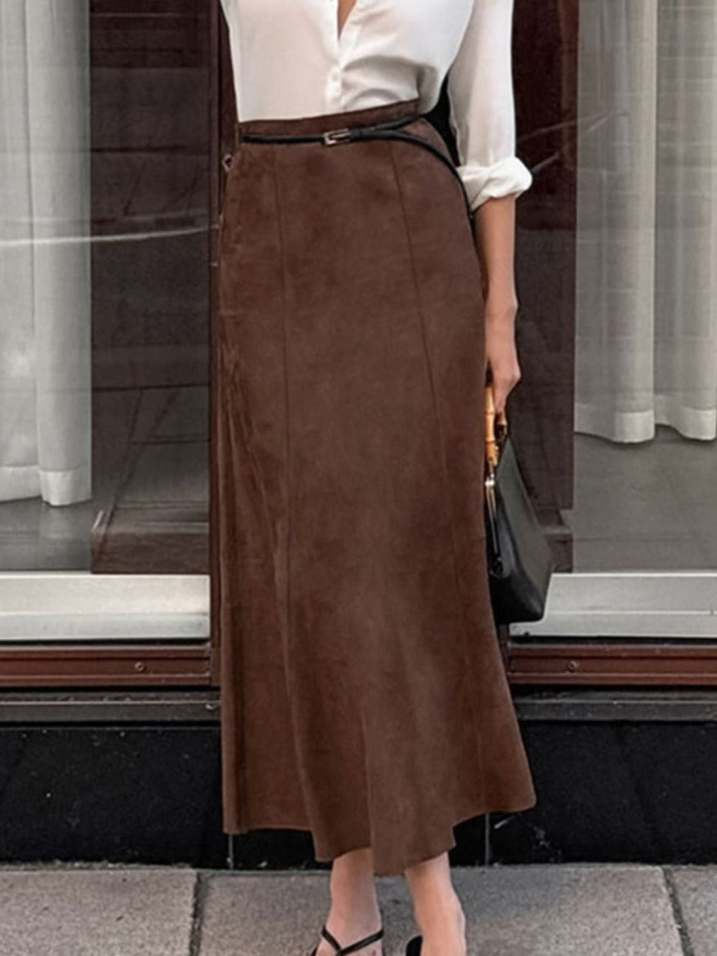 Dark brown suede midi skirt shown from the front with a slim belt