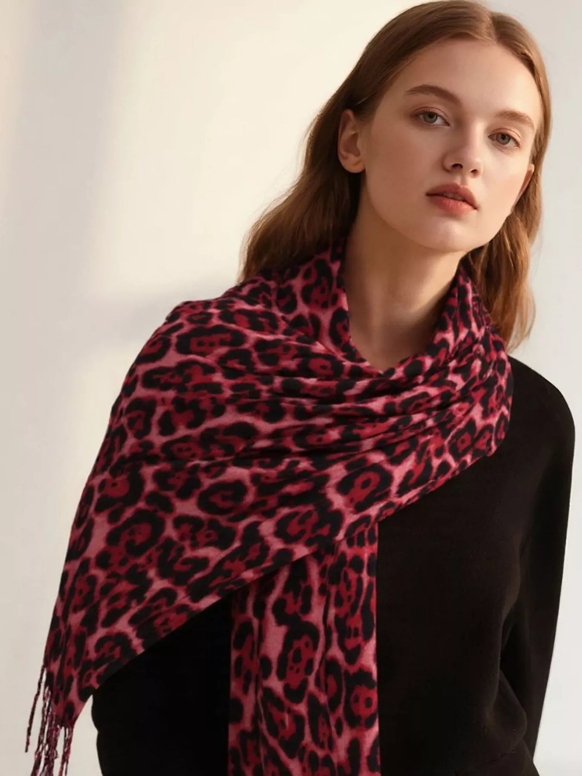 Leopard print fringe scarf in rose red with dark spots and lightweight drape.