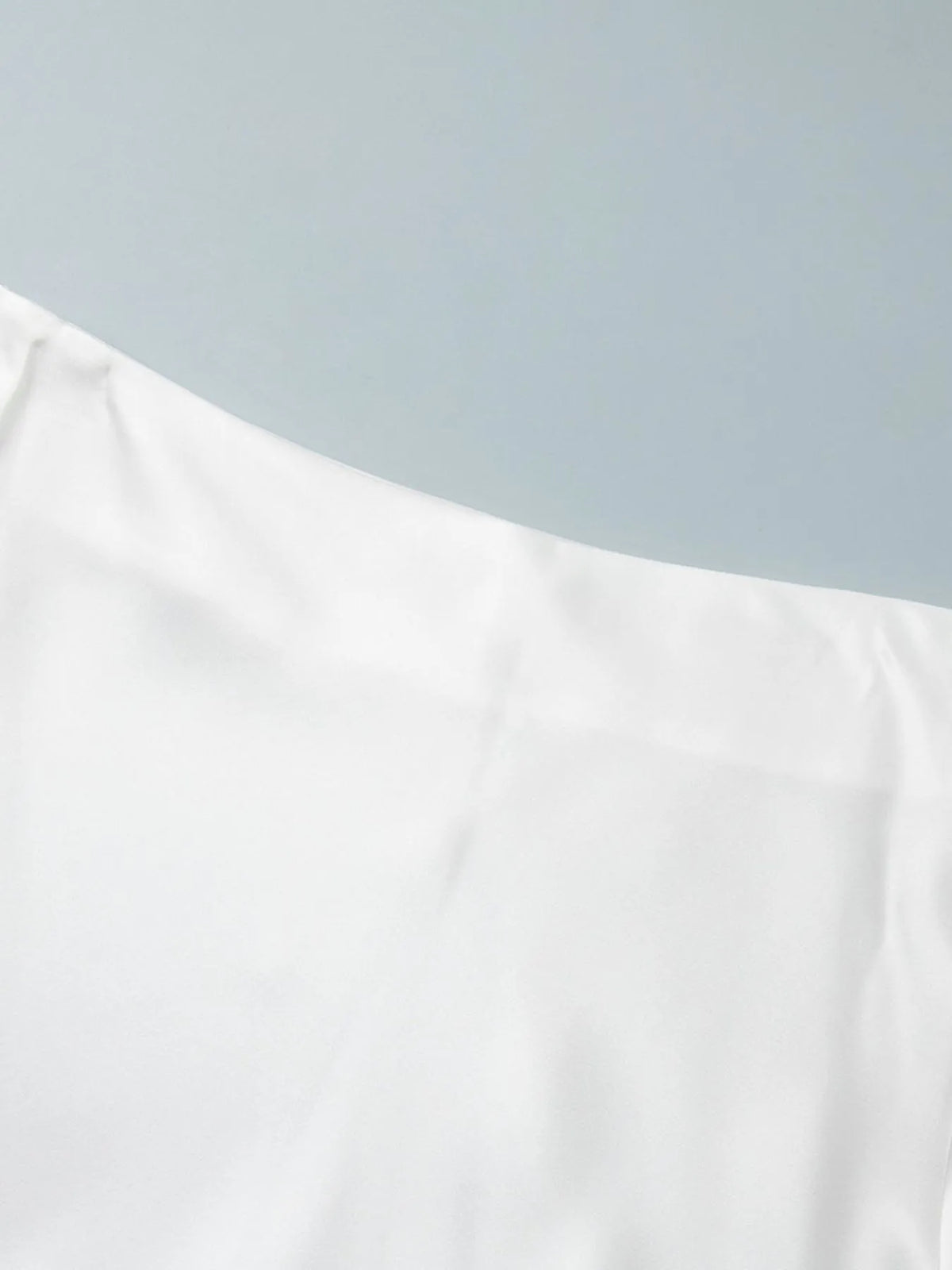 White high-waisted maxi skirt fabric panel with clean seam along the upper edge.