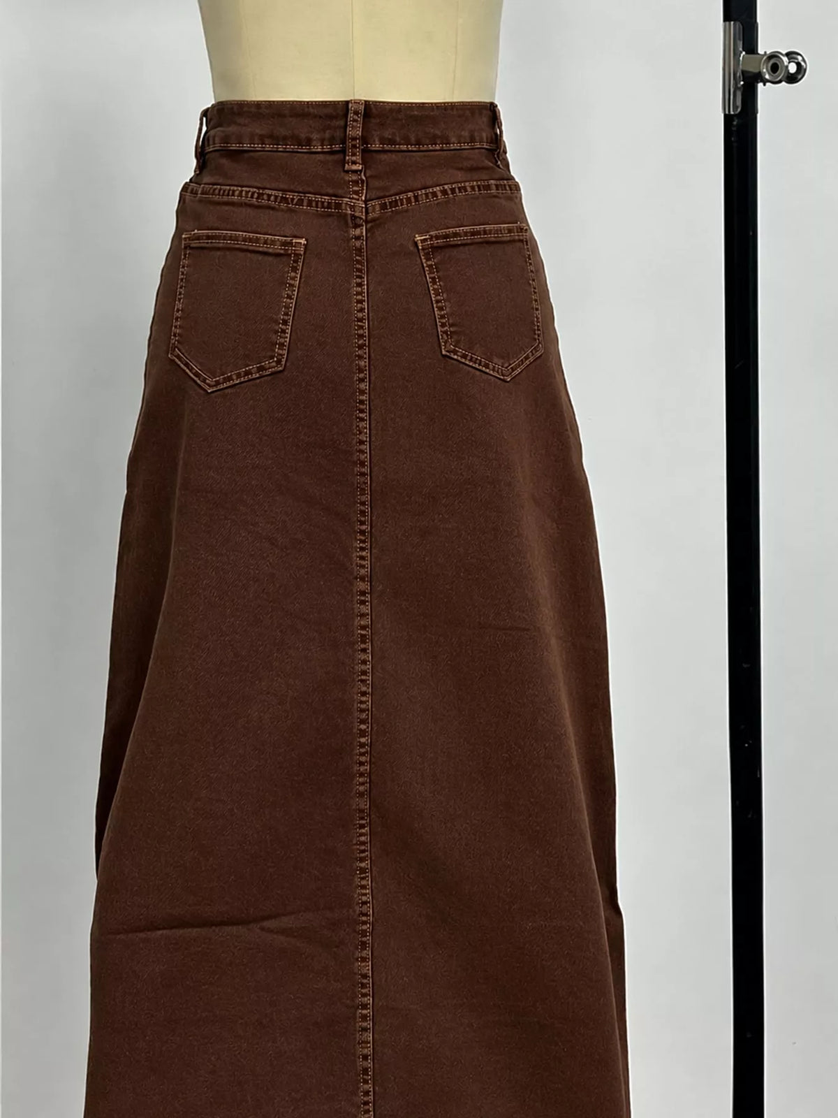 Coffee brown denim maxi skirt with high waist and two front patch pockets.