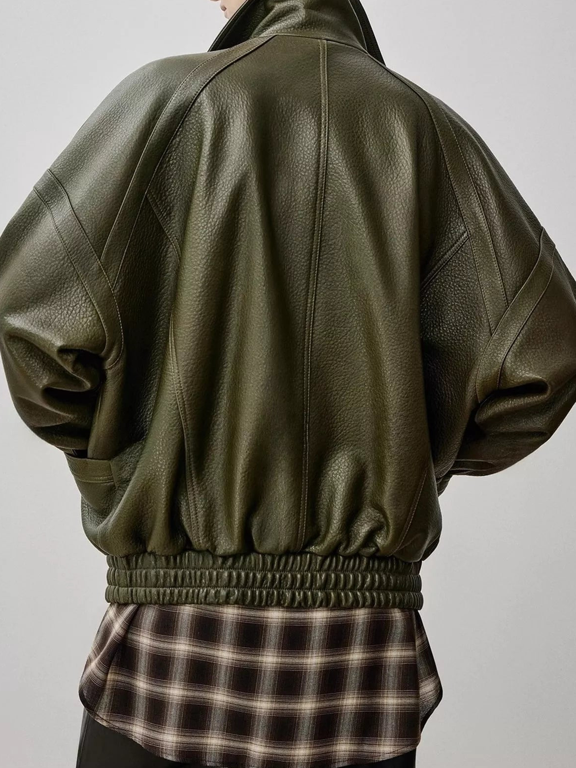 Dark green leather down jacket back view with gathered shoulders and ribbed waistband