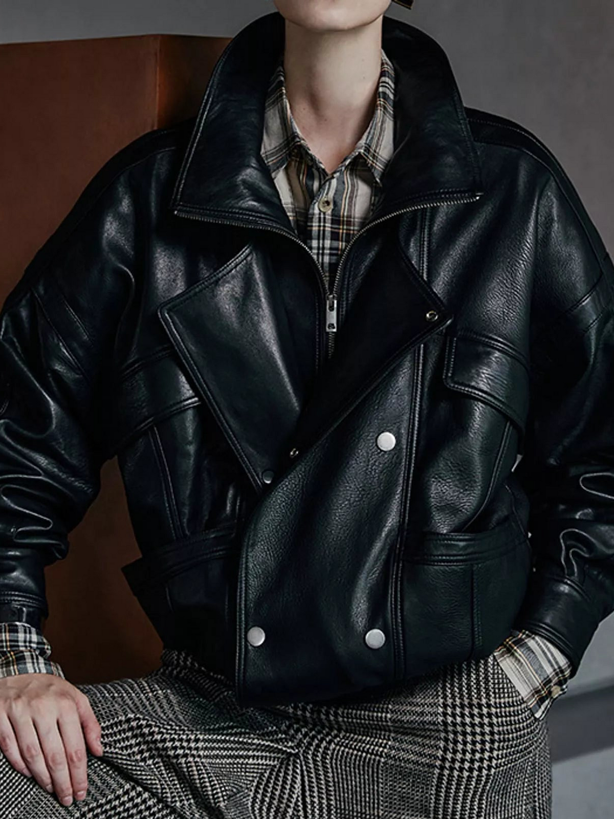 Black leather jacket with double-breasted flap pockets and snap buttons, front view