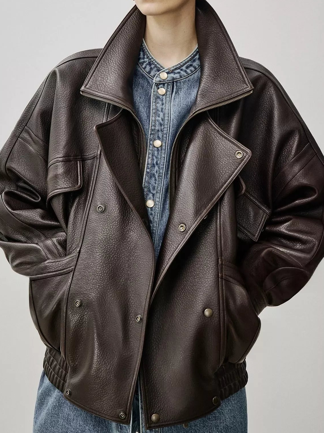 Dark brown leather jacket with shearling-style lining, double-breasted snaps, cropped view
